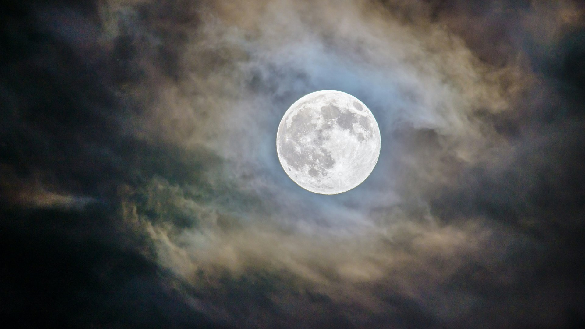 Vollmond mit Wolken und blauem Schimmer am Nachthimmel