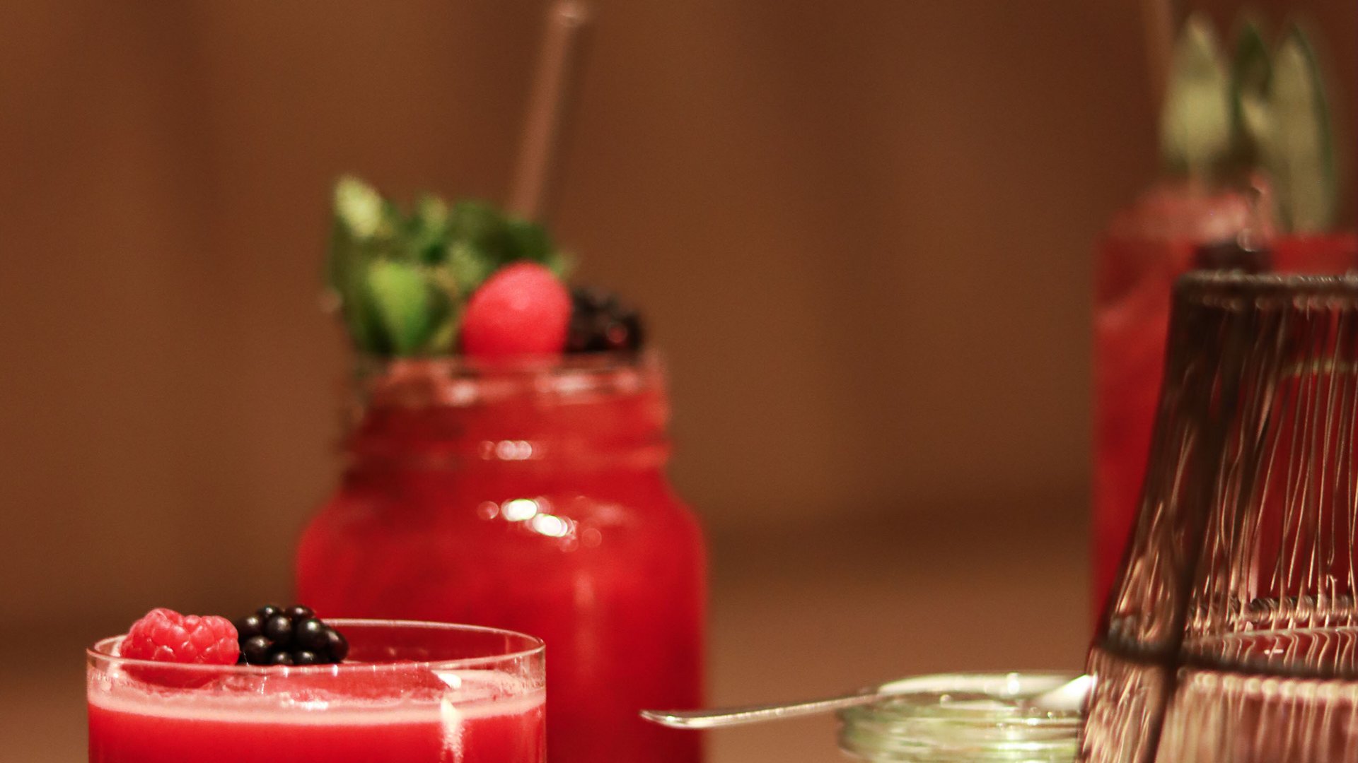 Rote Beeren-Cocktails in Gläsern auf einem weißen Tisch
