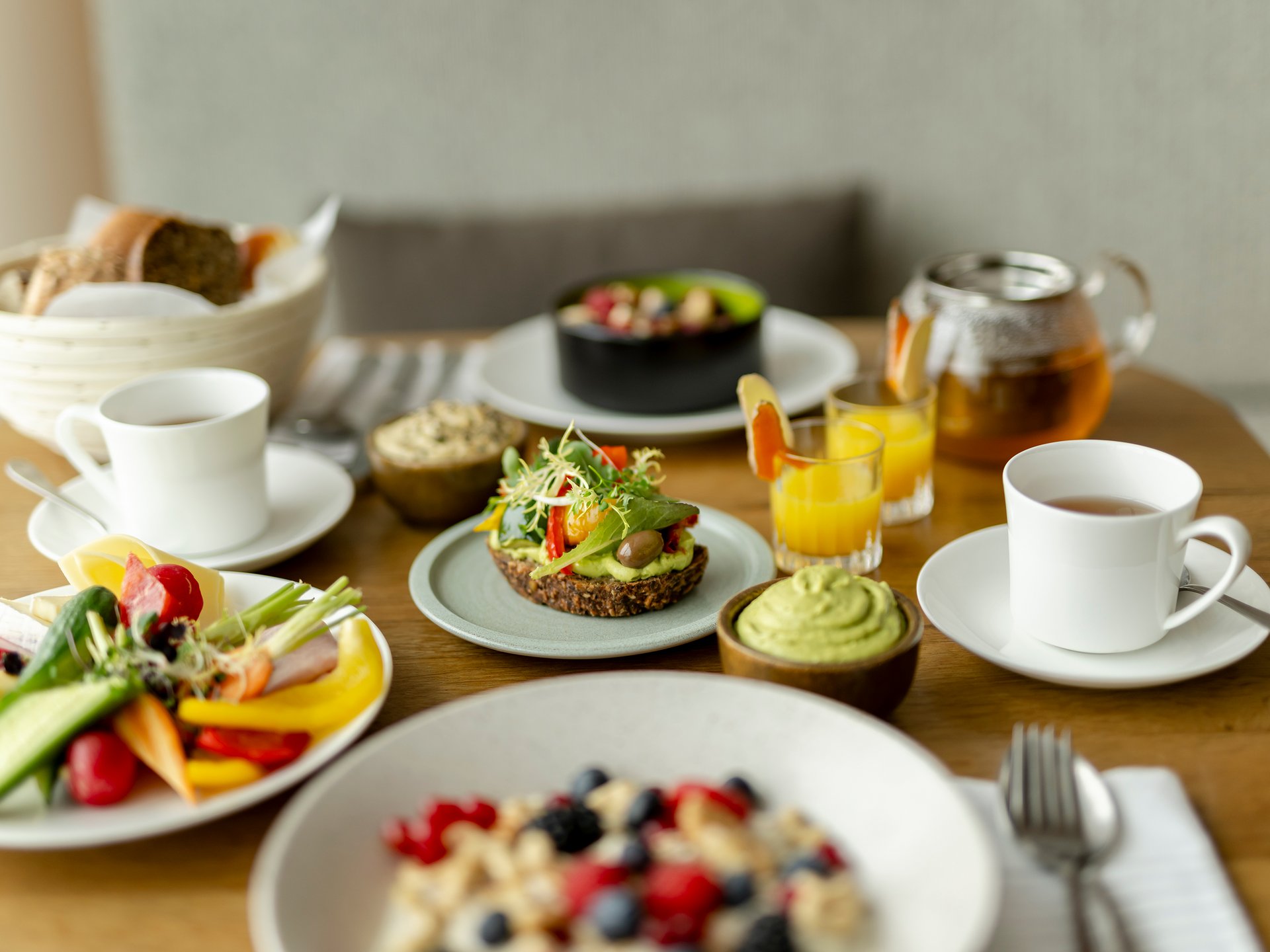 Gesundes Frühstück mit Obst, Gemüse, Saft und Tee auf Holztisch