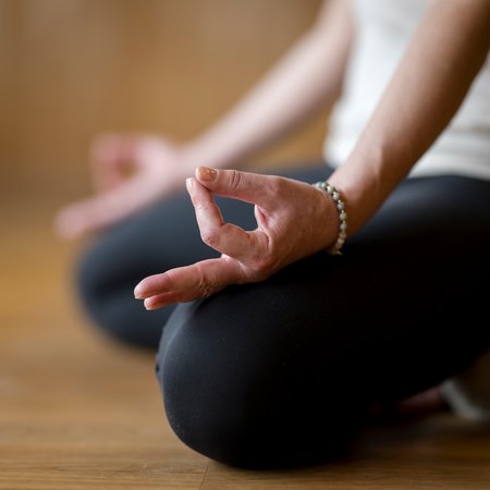 Nahaufnahme von Händen in Meditationshaltung beim Yoga