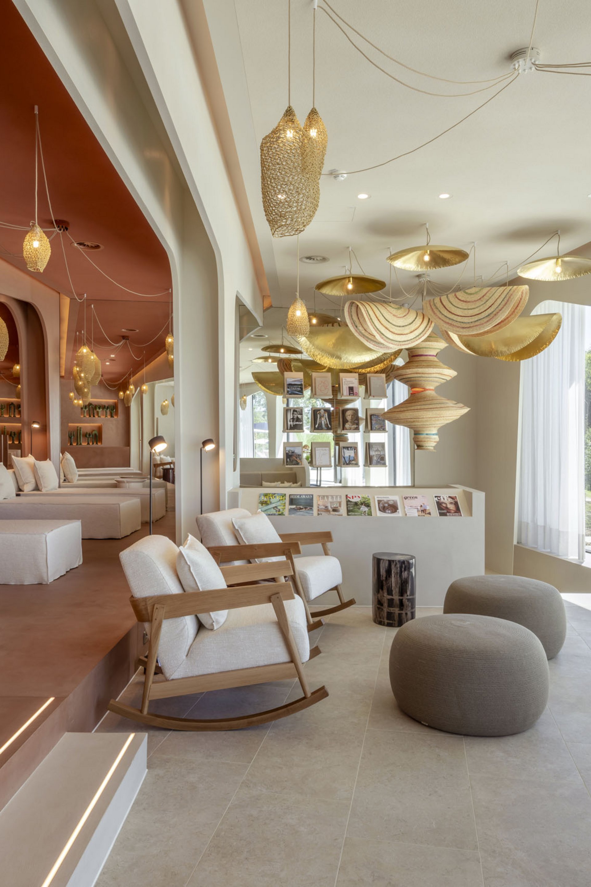 Helle Lounge mit gemütlichen Sesseln, Poufs und dekorativen Lampen
