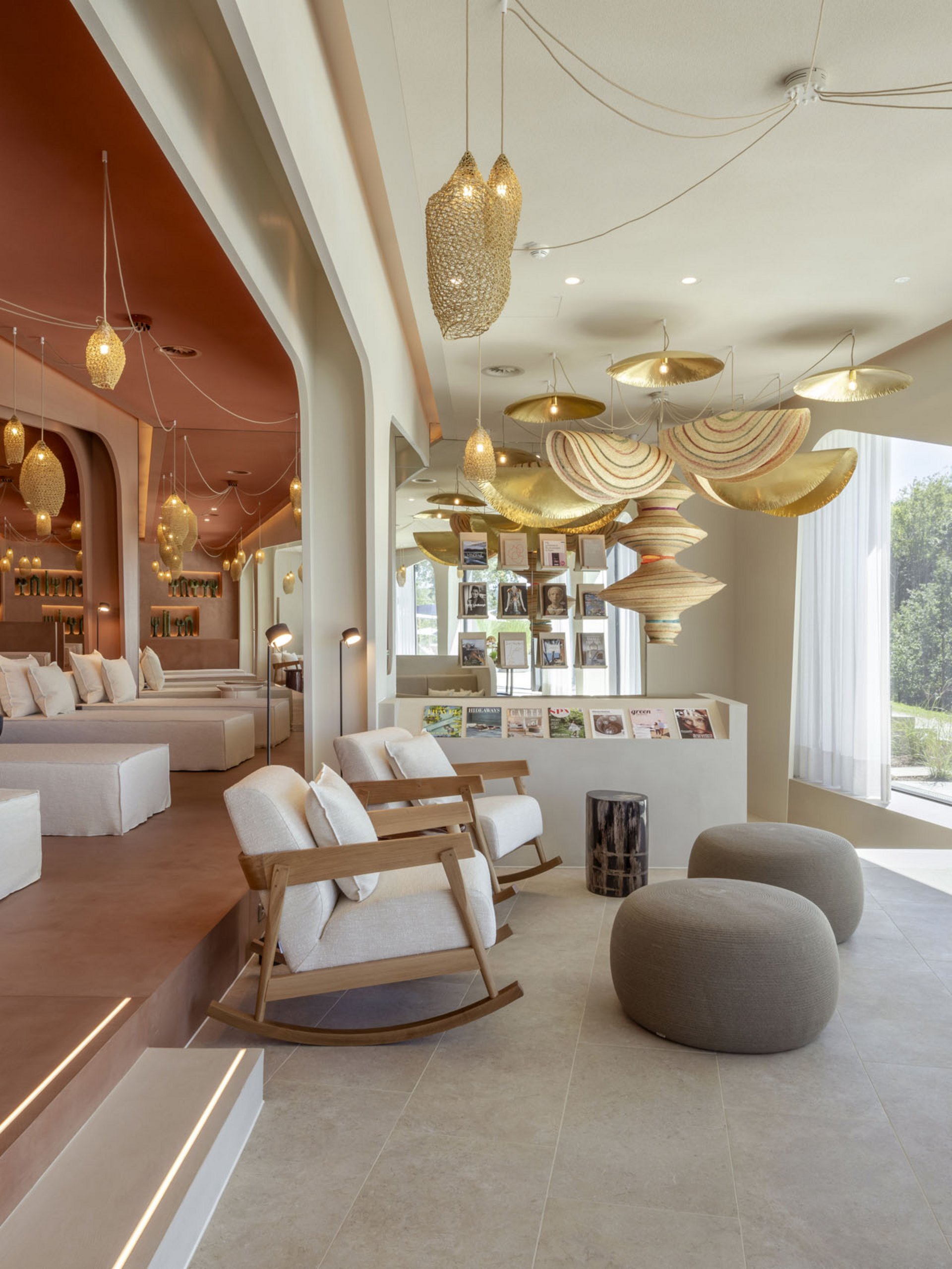 Helle Lounge mit gemütlichen Sesseln, Poufs und dekorativen Lampen