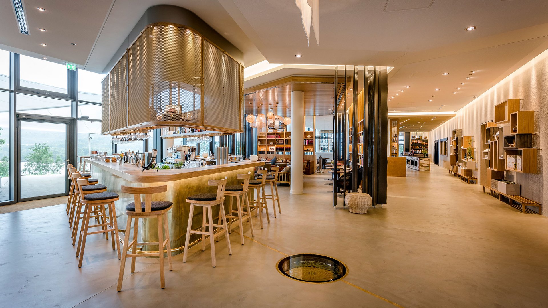 Modern bright bar area with wooden stools and large windows