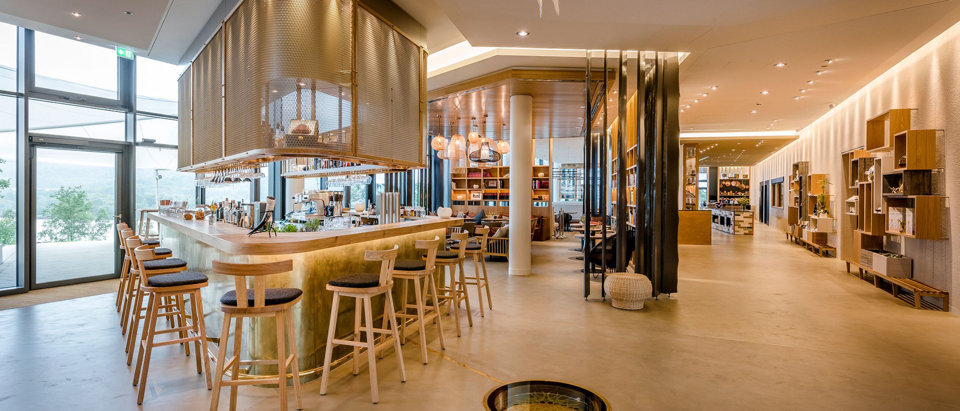 Bar moderne lumineuse avec chaises en bois et grandes fenêtres