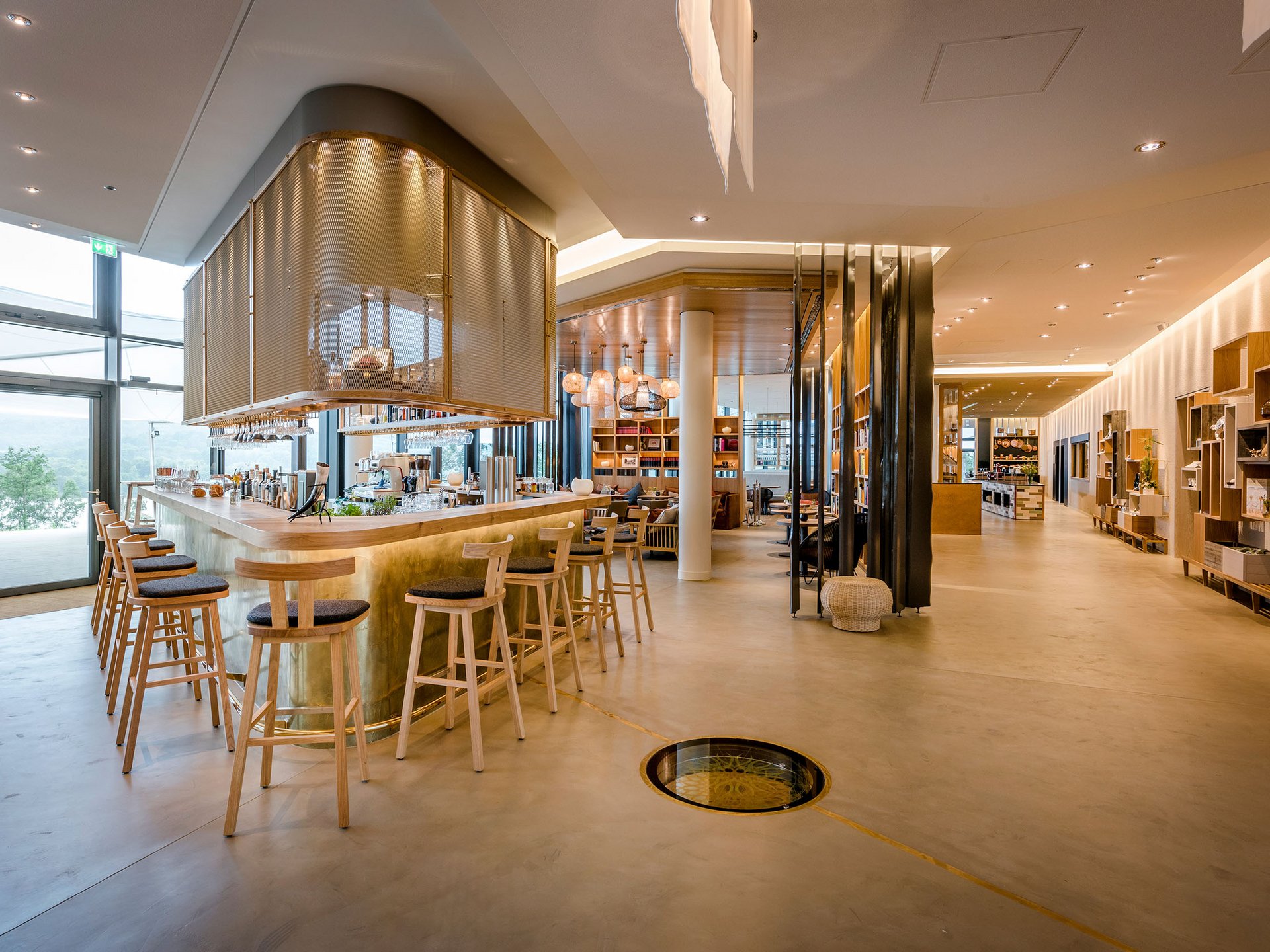 Bar moderne lumineuse avec chaises en bois et grandes fenêtres