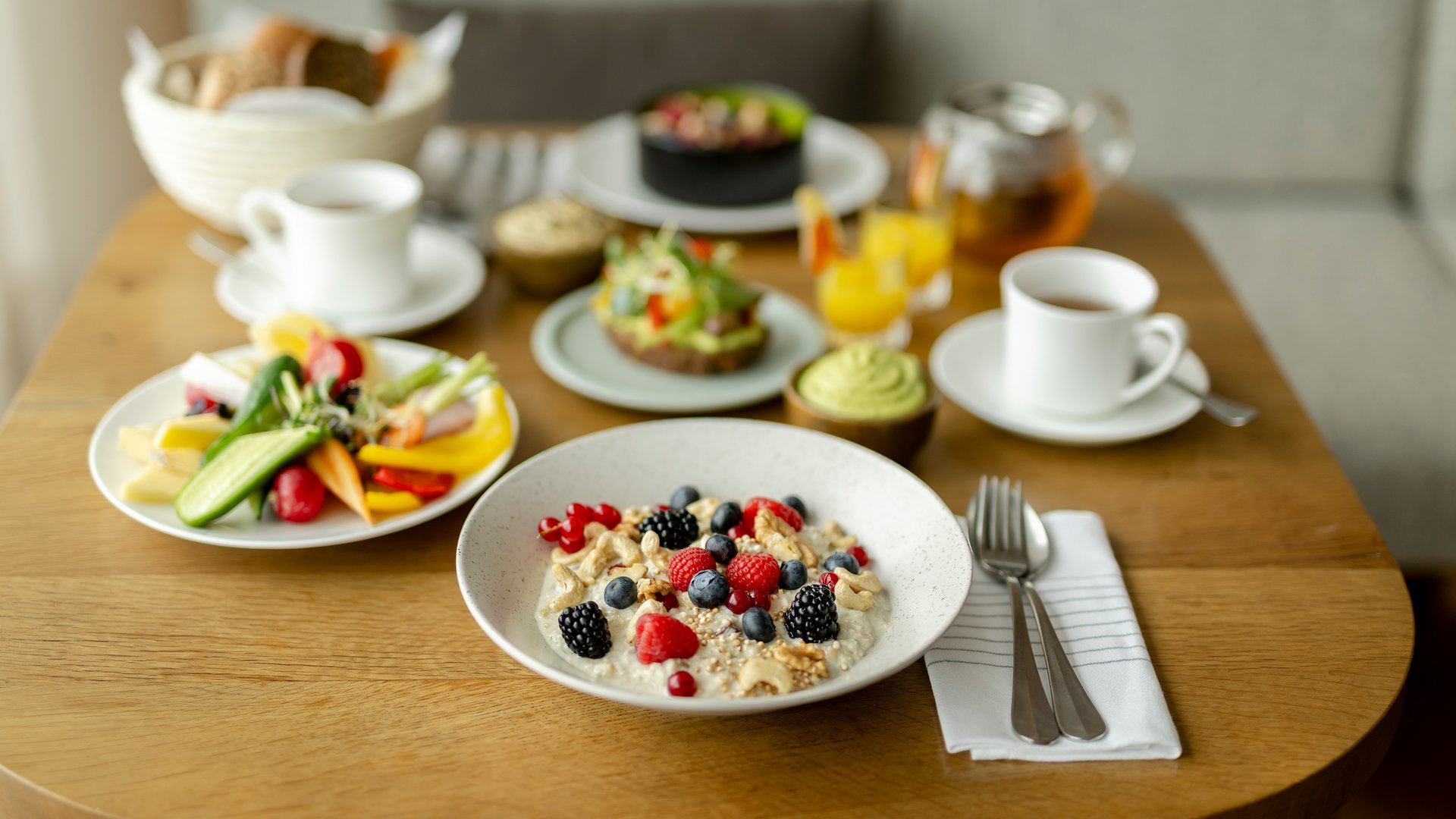 Gesunder Frühstückstisch mit Müsli, Beeren, Gemüse und Getränken