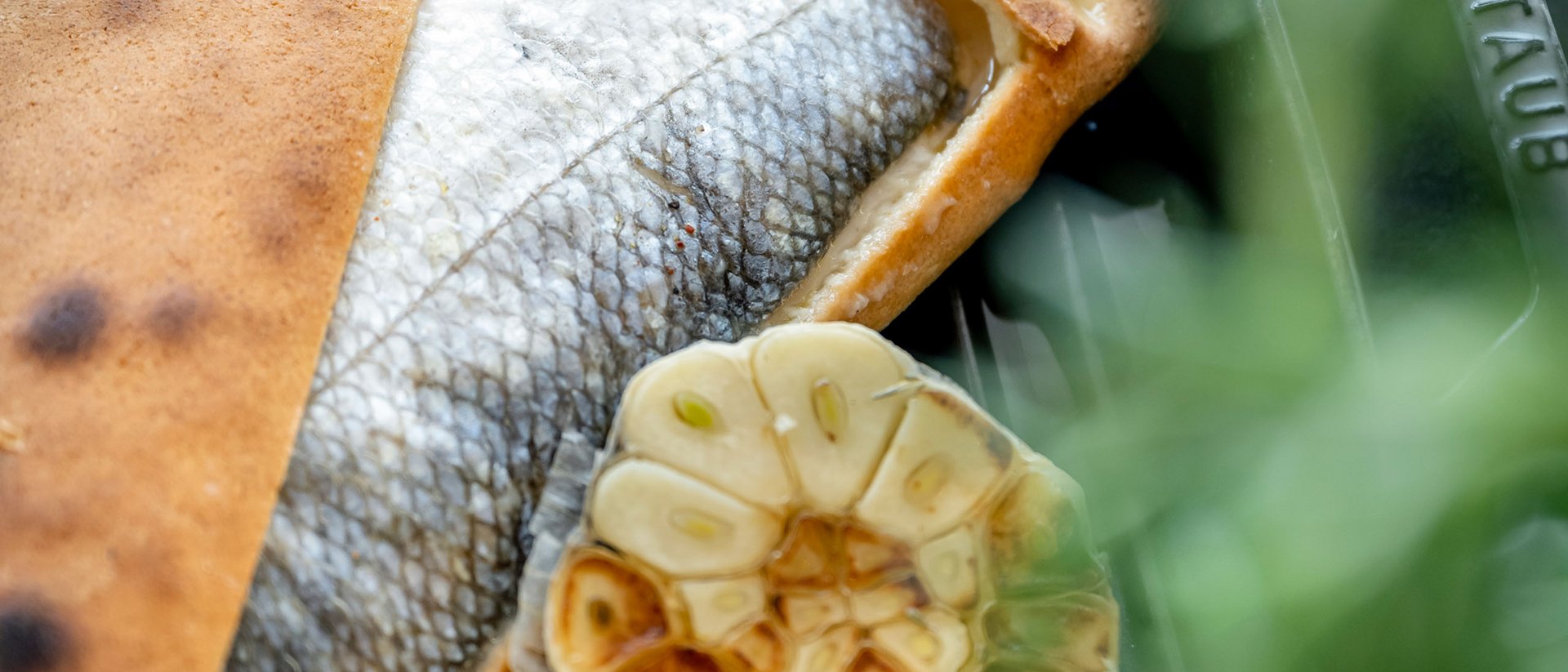 Gebackener Fisch mit geröstetem Knoblauch und Zitrone auf Grillpfanne