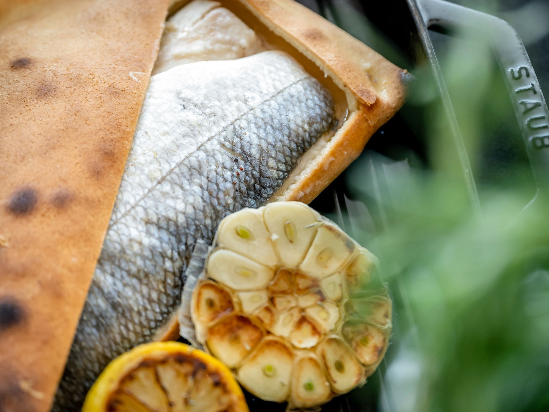Gebackener Fisch mit geröstetem Knoblauch und Zitrone auf Grillpfanne