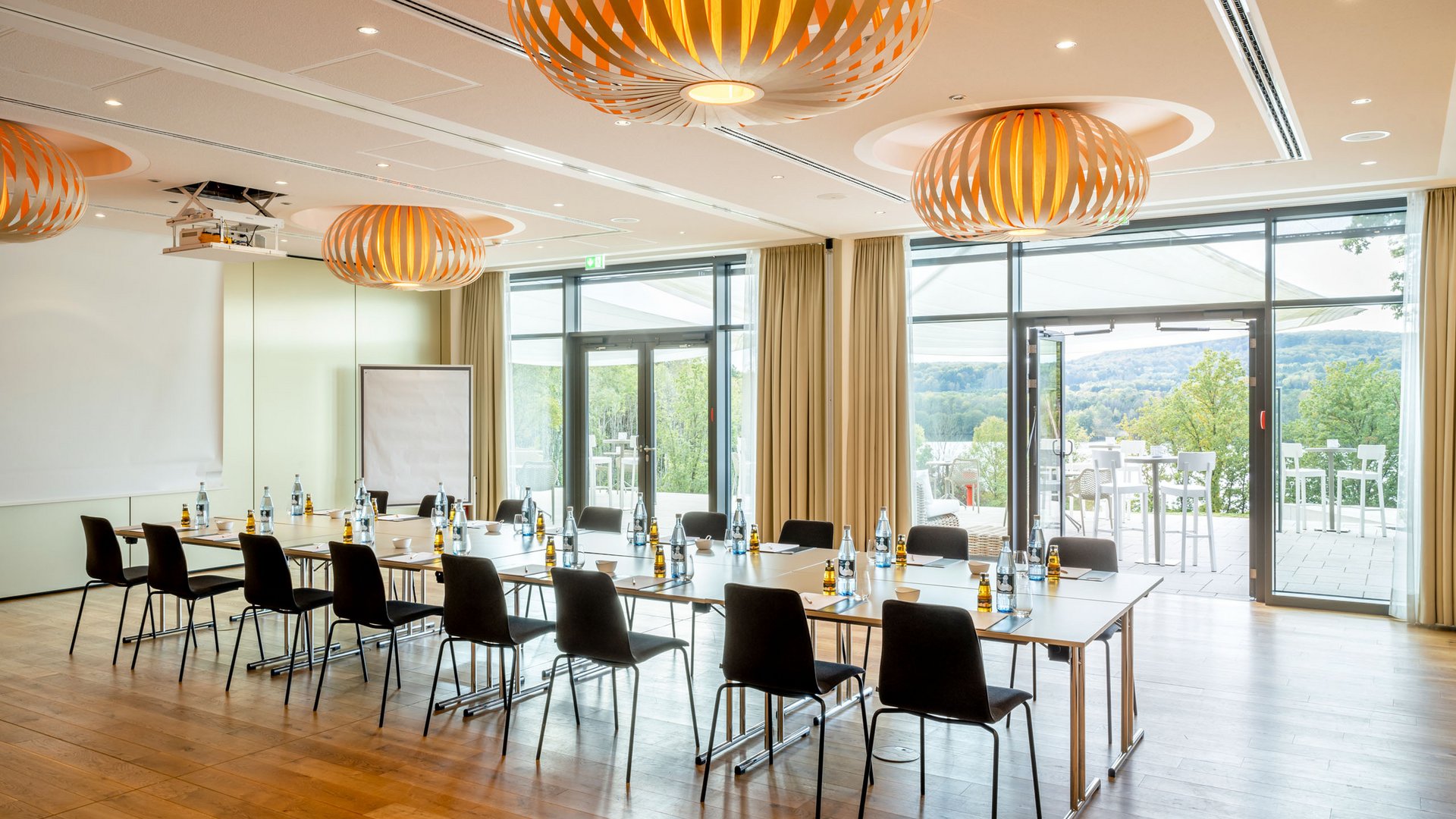 Salle de réunion moderne en U avec vue sur terrasse et paysage naturel