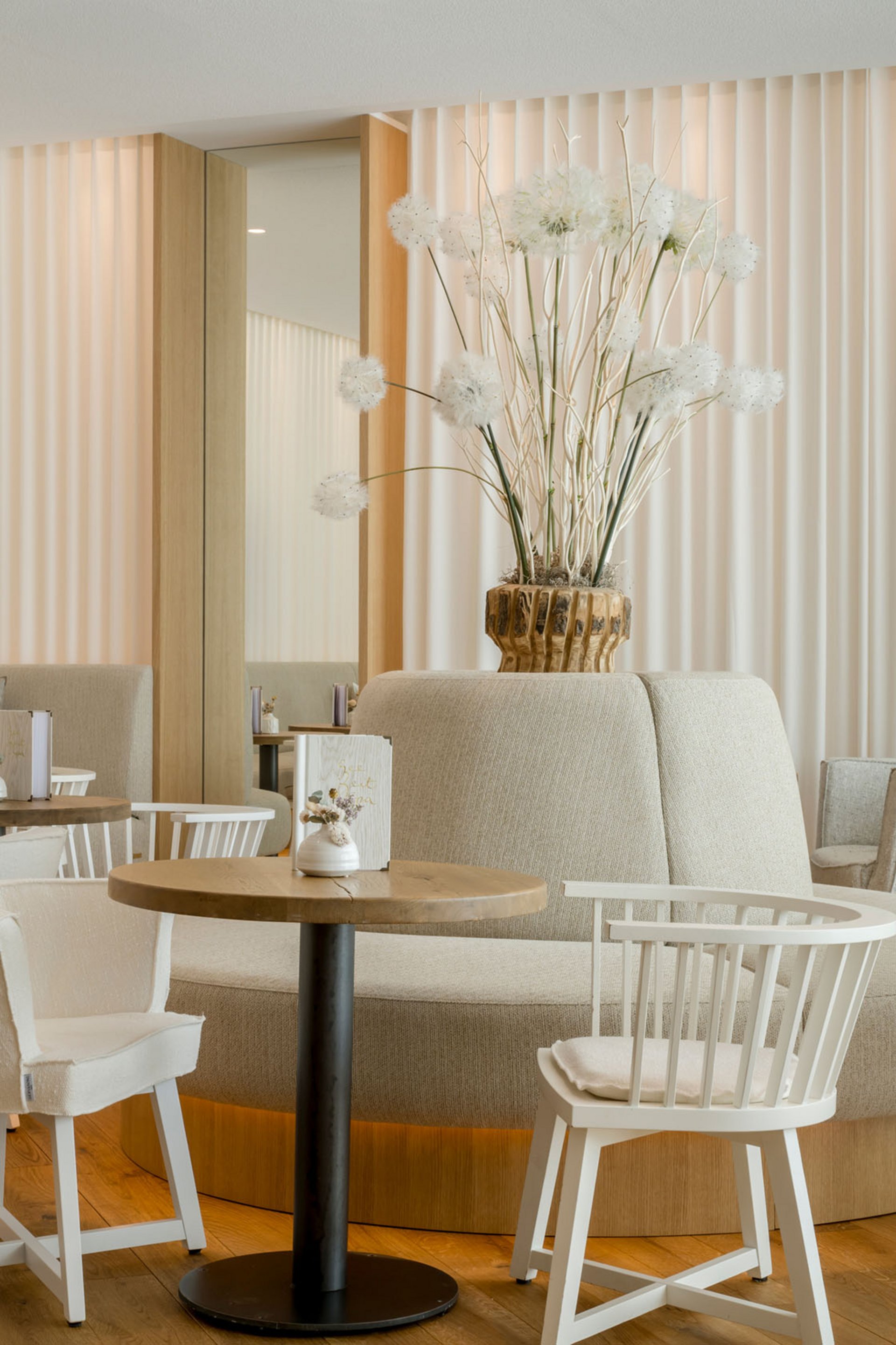 Café moderne et lumineux avec meubles blancs et décor floral