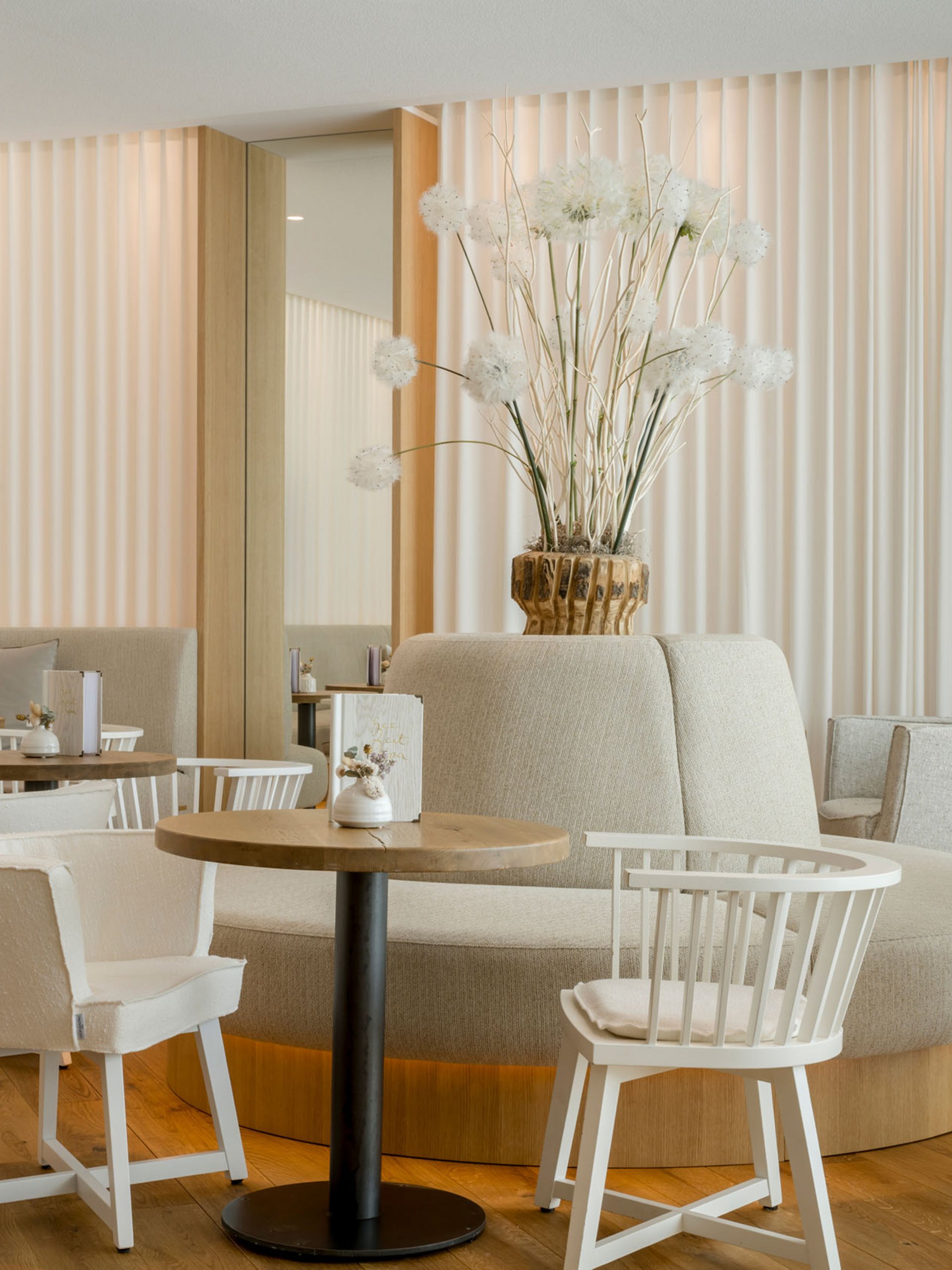 Bright modern café with white furniture and floral decoration