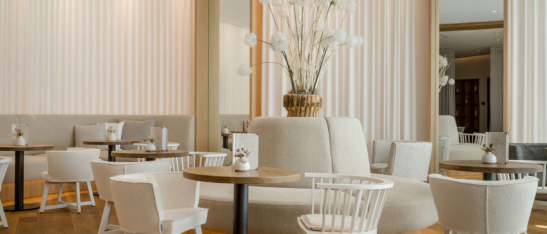Café moderne et lumineux avec meubles blancs et décor floral