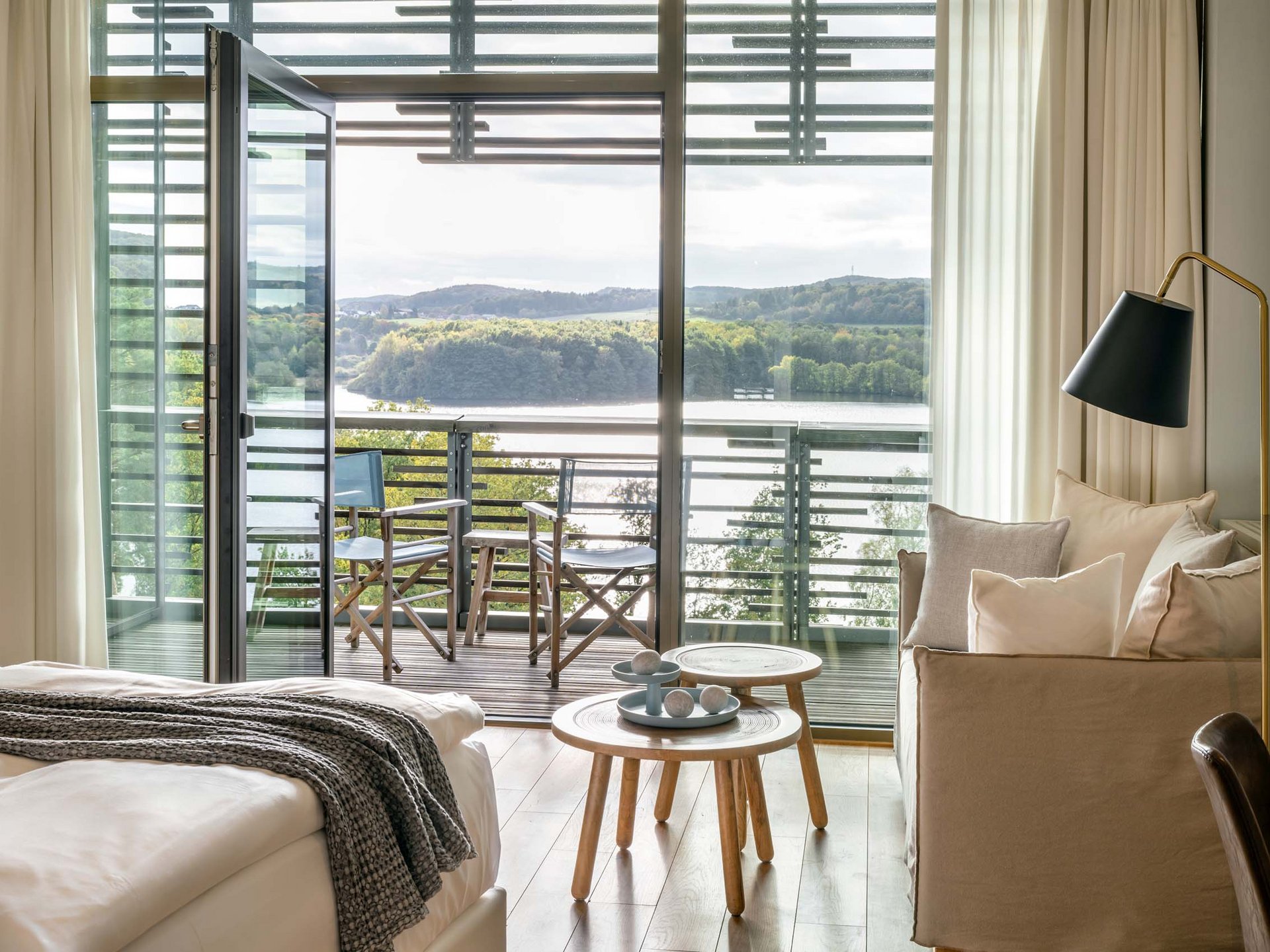 Gemütliches Hotelzimmer mit Balkon und Blick auf See und Wald