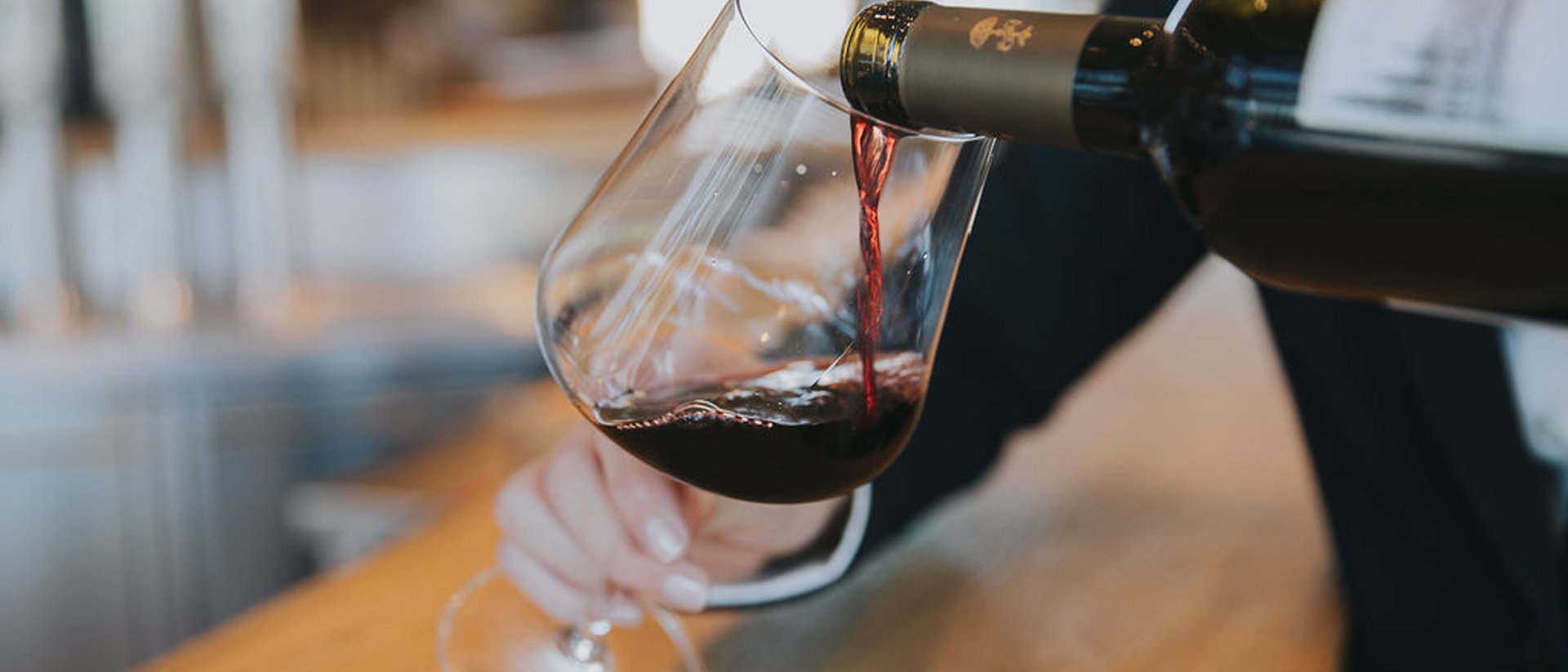 Du vin rouge versé dans un verre au comptoir