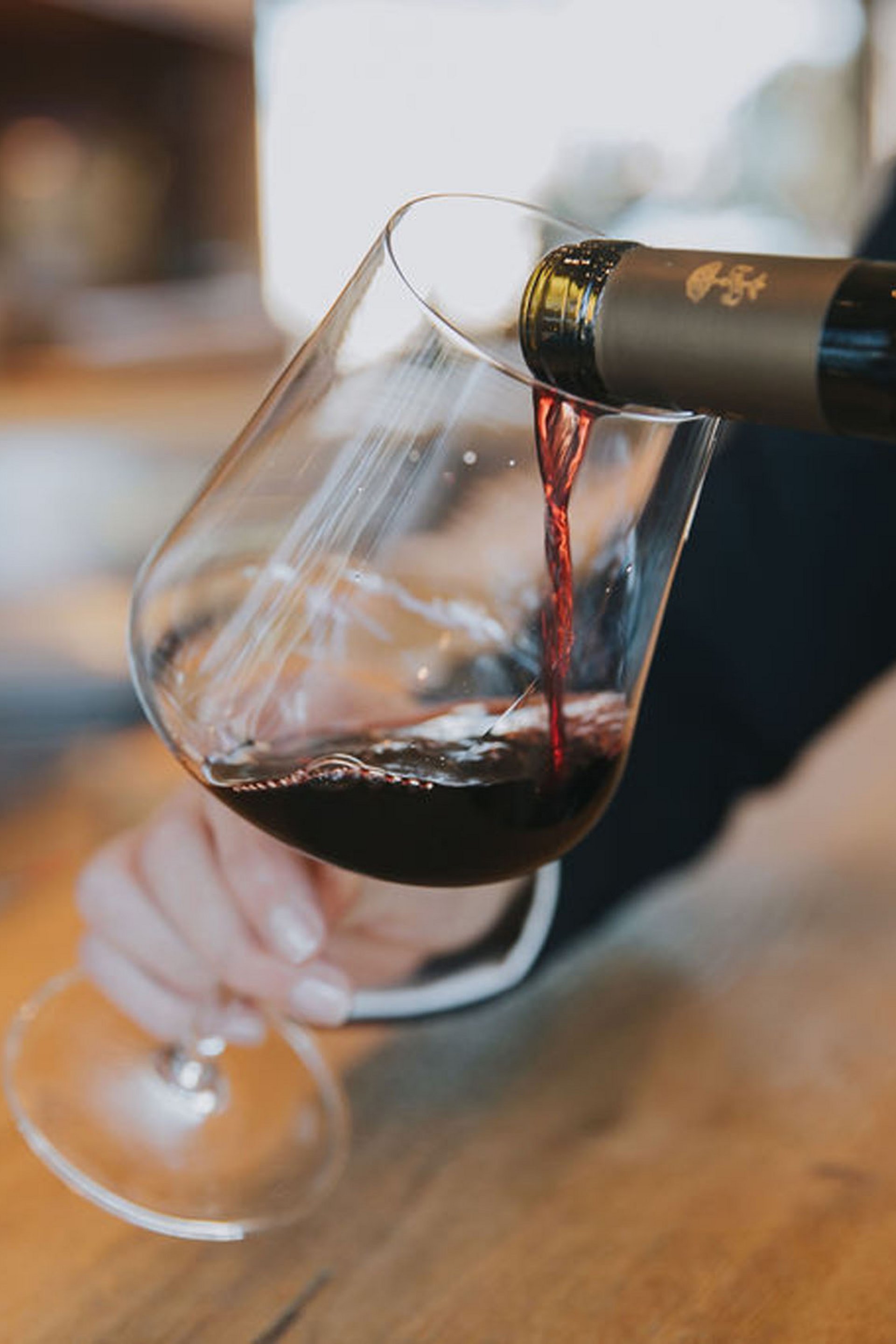 Du vin rouge versé dans un verre au comptoir