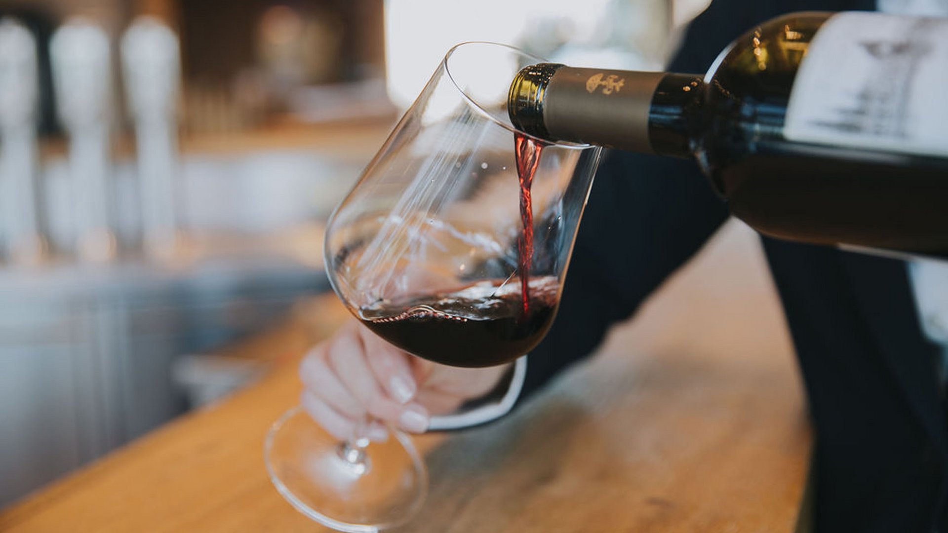 Du vin rouge versé dans un verre au comptoir