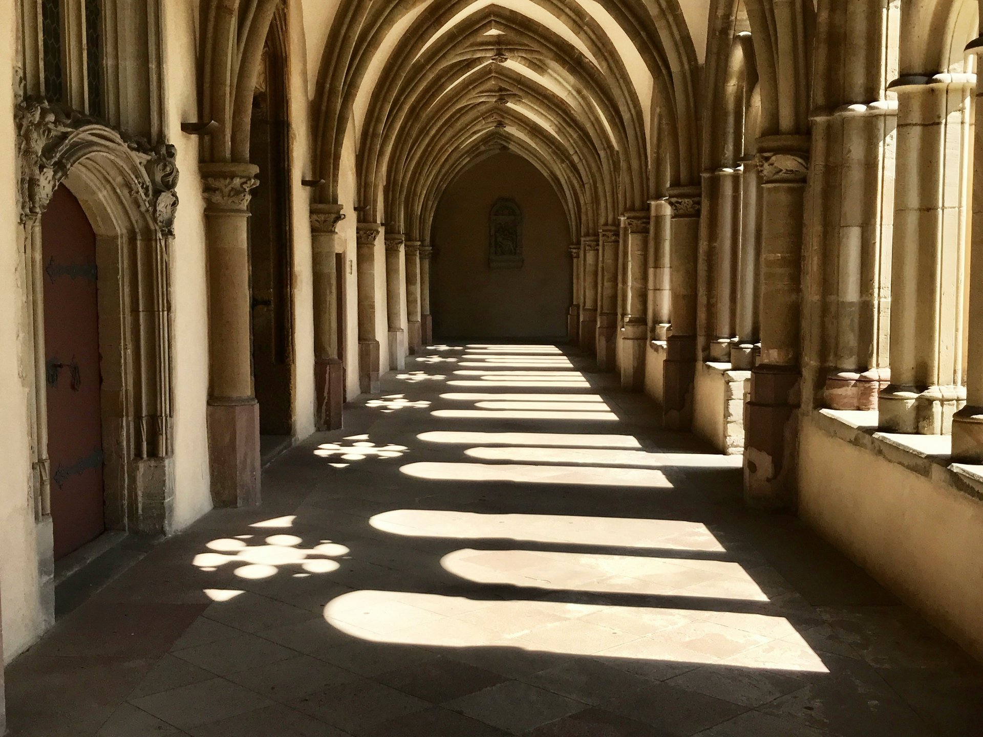 Licht und Schatten in einem gotischen Klostergang mit Spitzbögen