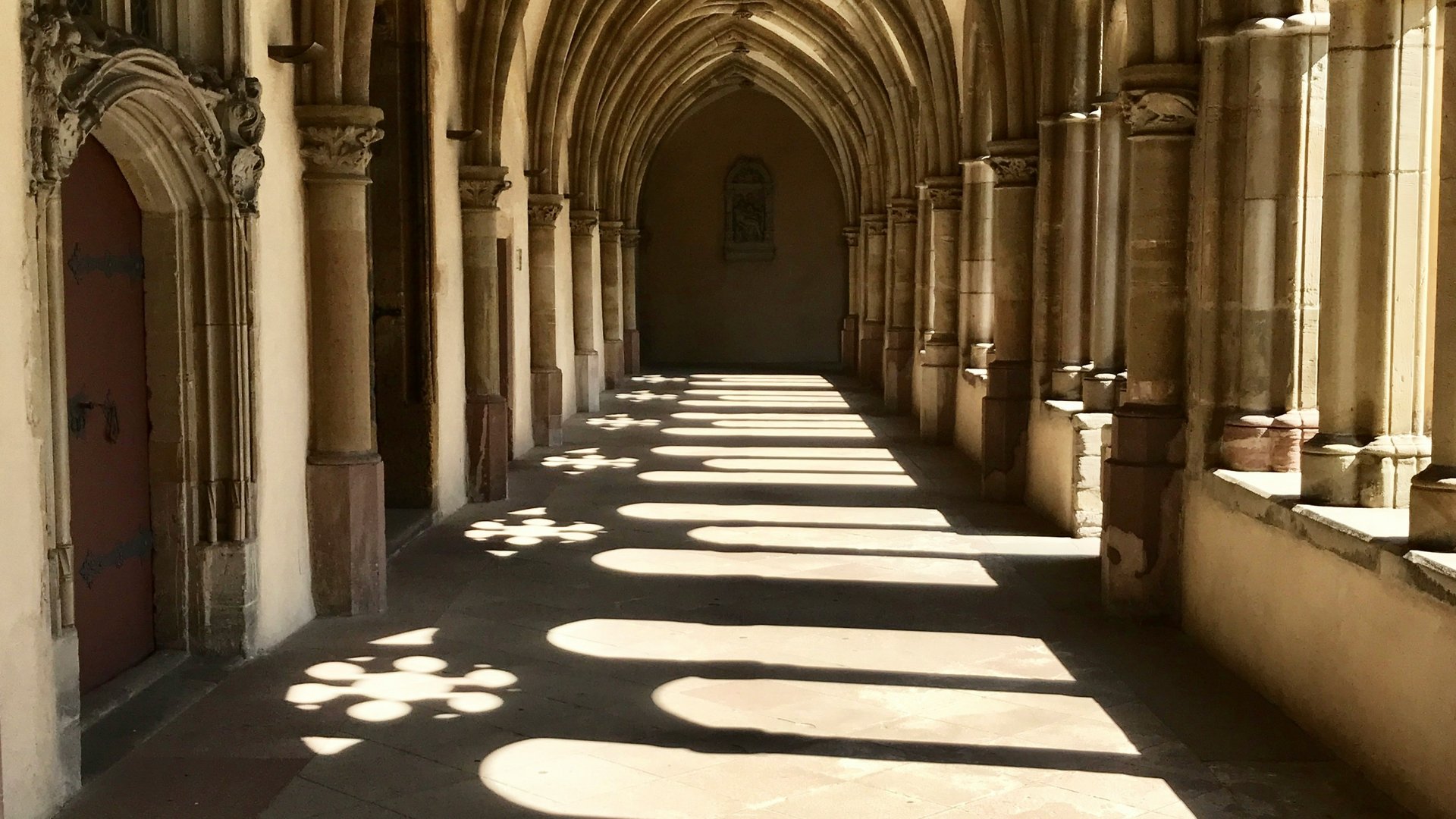 Licht und Schatten in einem gotischen Klostergang mit Spitzbögen