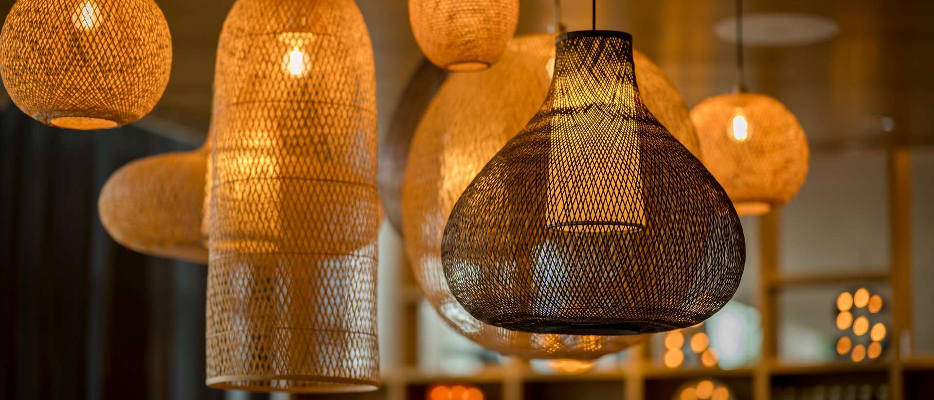 Various glowing woven hanging lamps emitting warm light