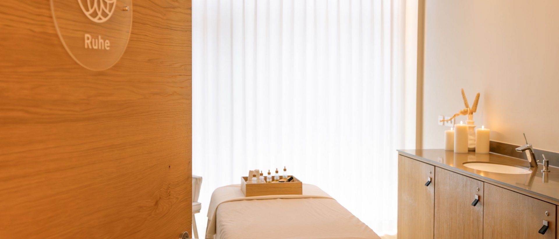 Massageraum mit Behandlungsliege, Kerzen und Aromastoffen für Ruhe