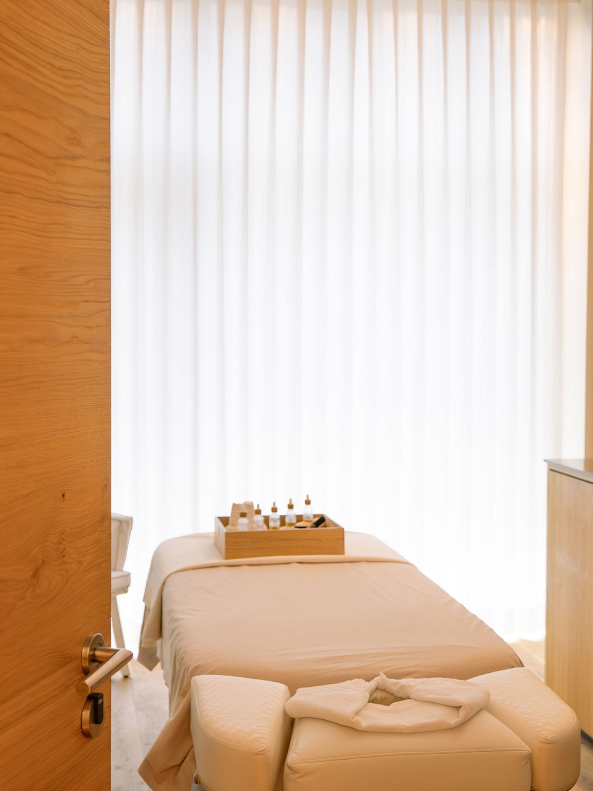 Salle de massage avec table de soin, bougies et huiles essentielles pour détente