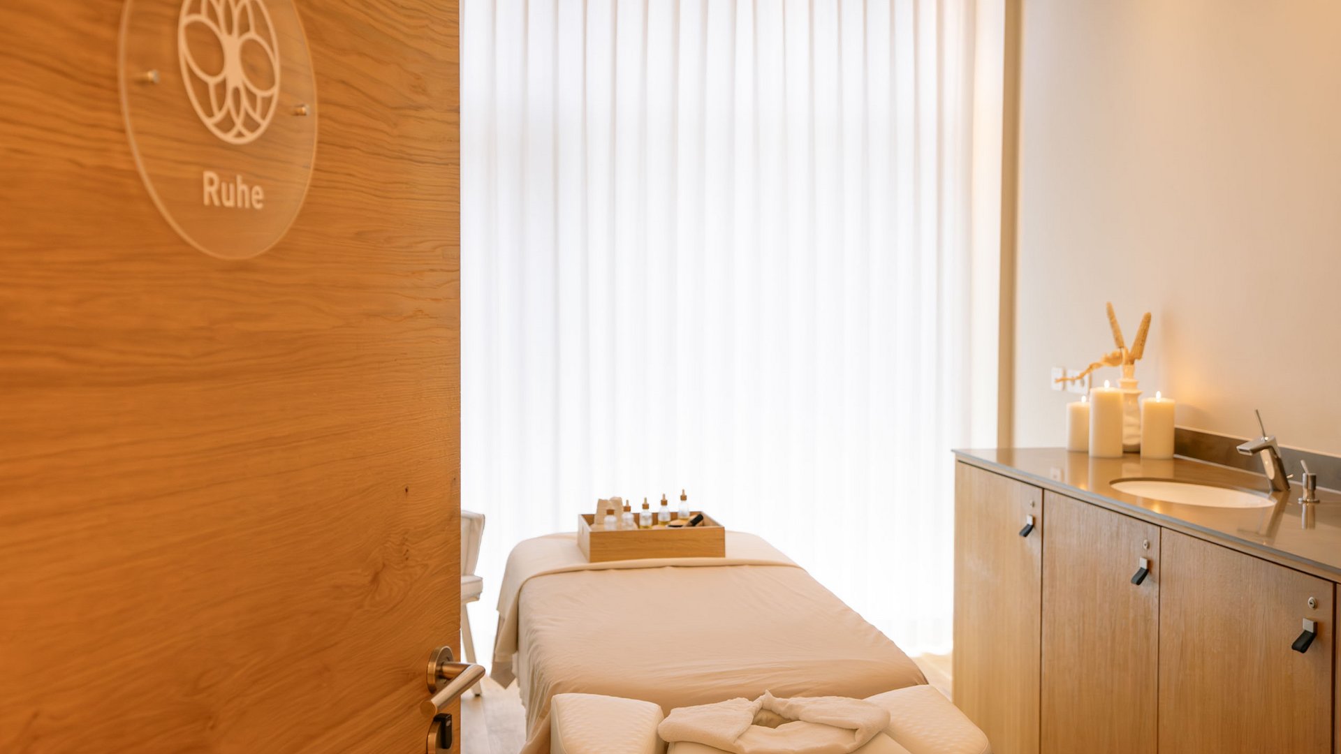 Massageraum mit Behandlungsliege, Kerzen und Aromastoffen für Ruhe