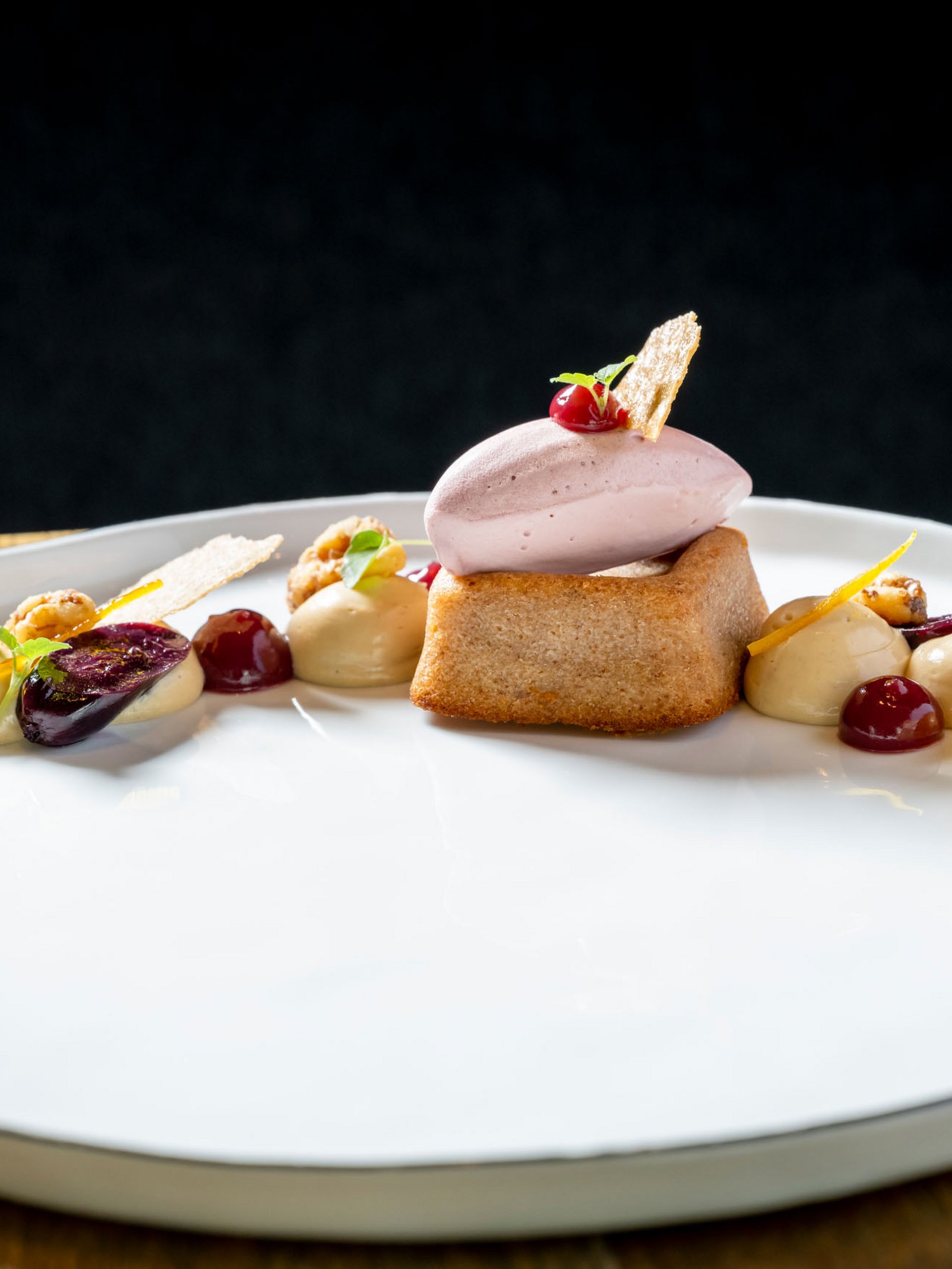 Dessert élégant avec biscuit, glace et sauces fruitées sur assiette blanche