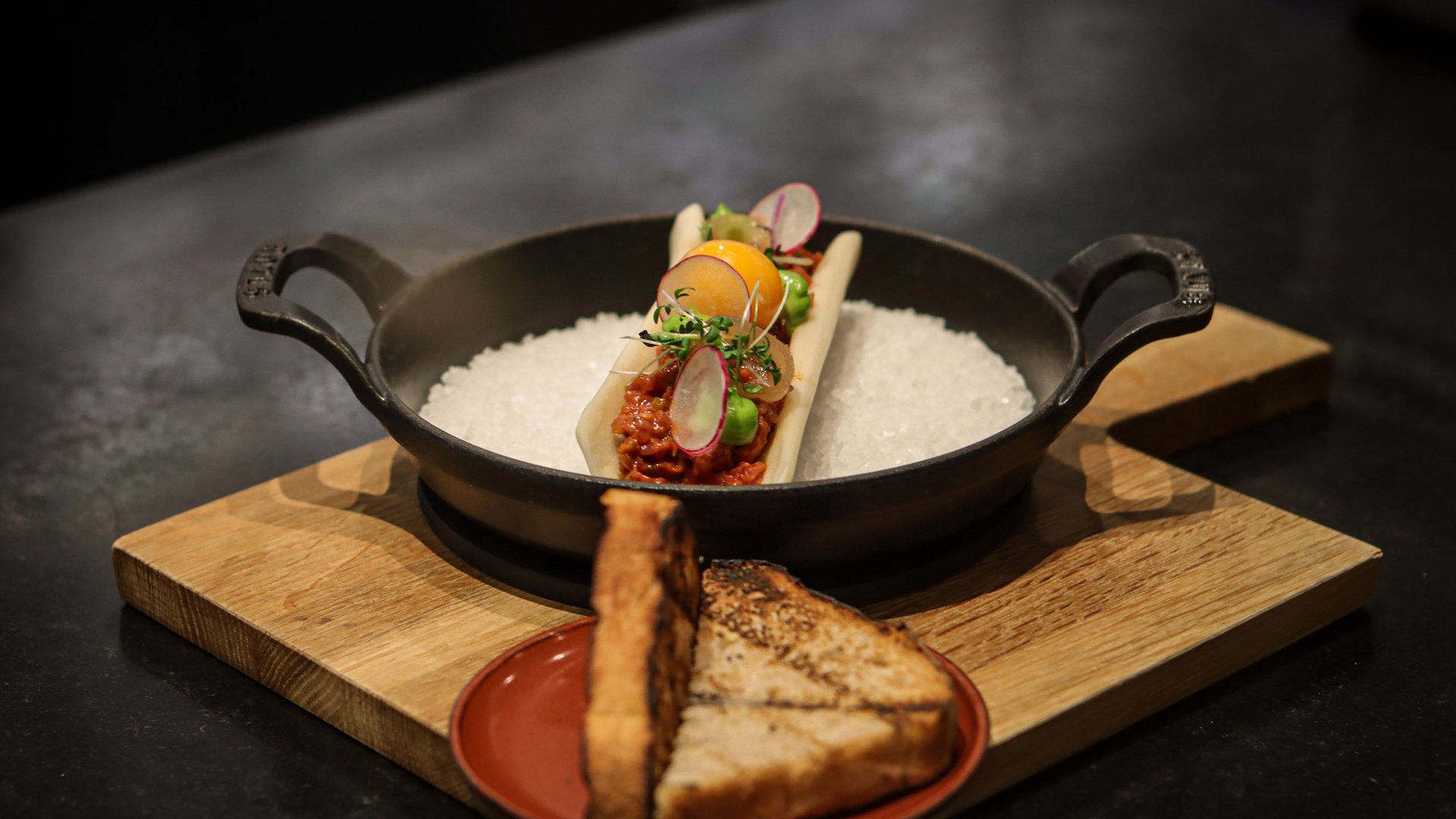 Plat fin garni avec du pain grillé sur une planche en bois