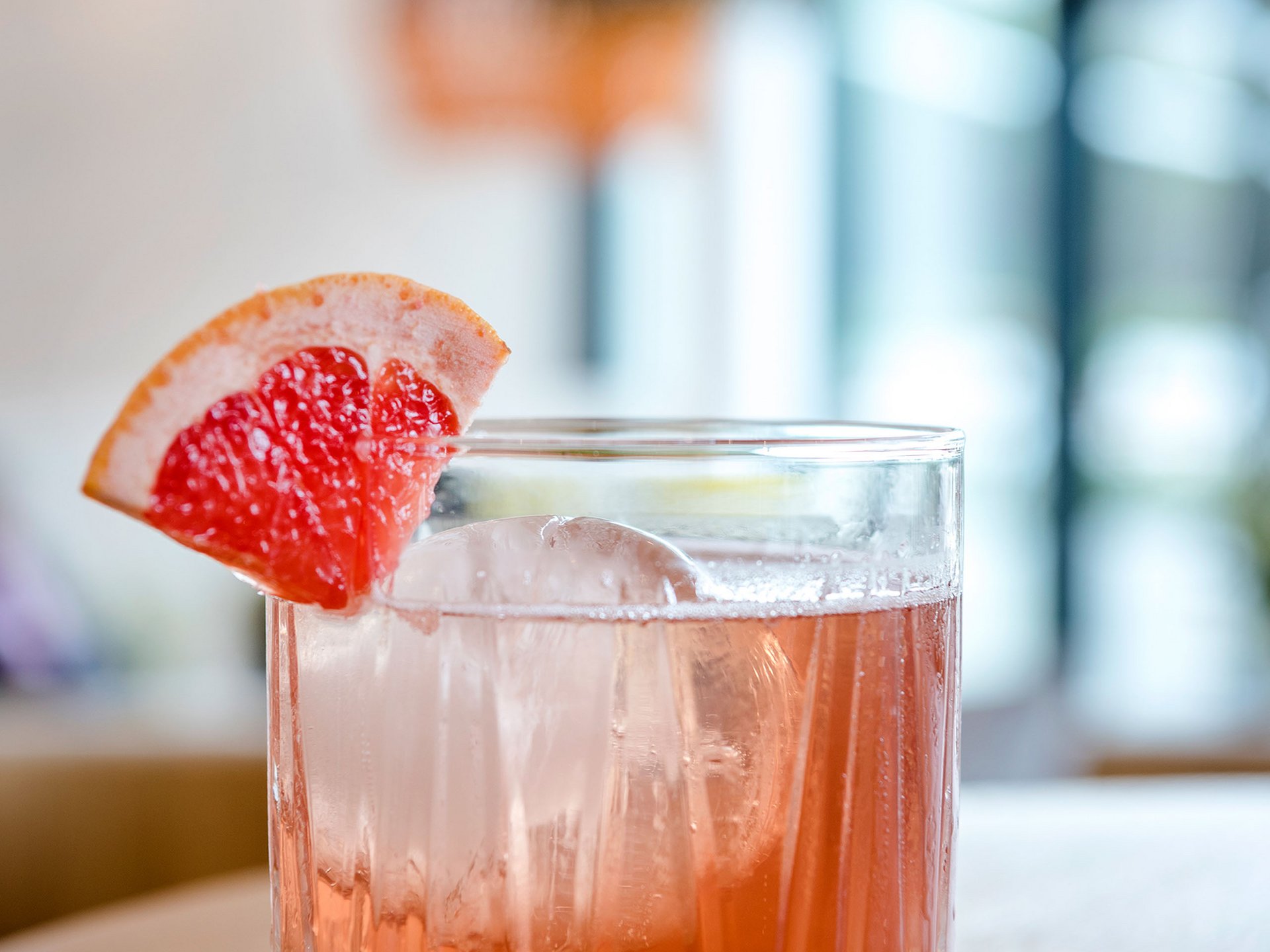 Cocktail avec glace et tranche de pamplemousse sur table en bois