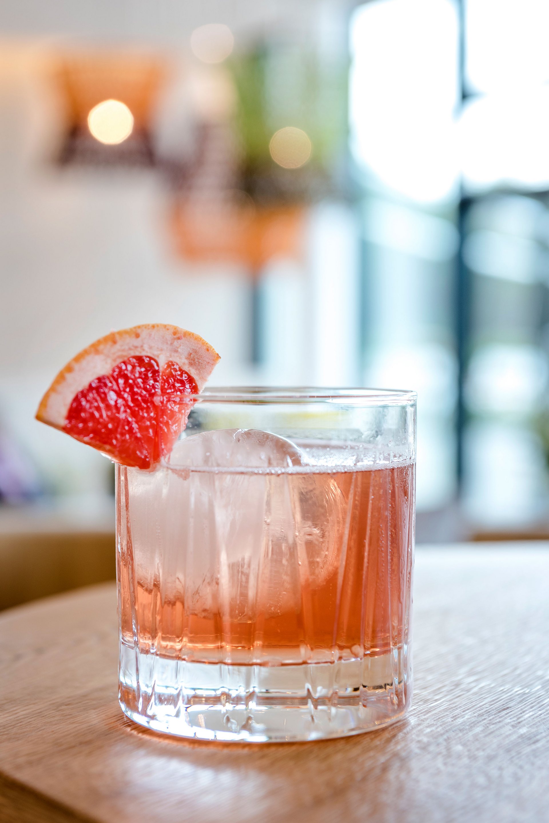 Cocktail avec glace et tranche de pamplemousse sur table en bois