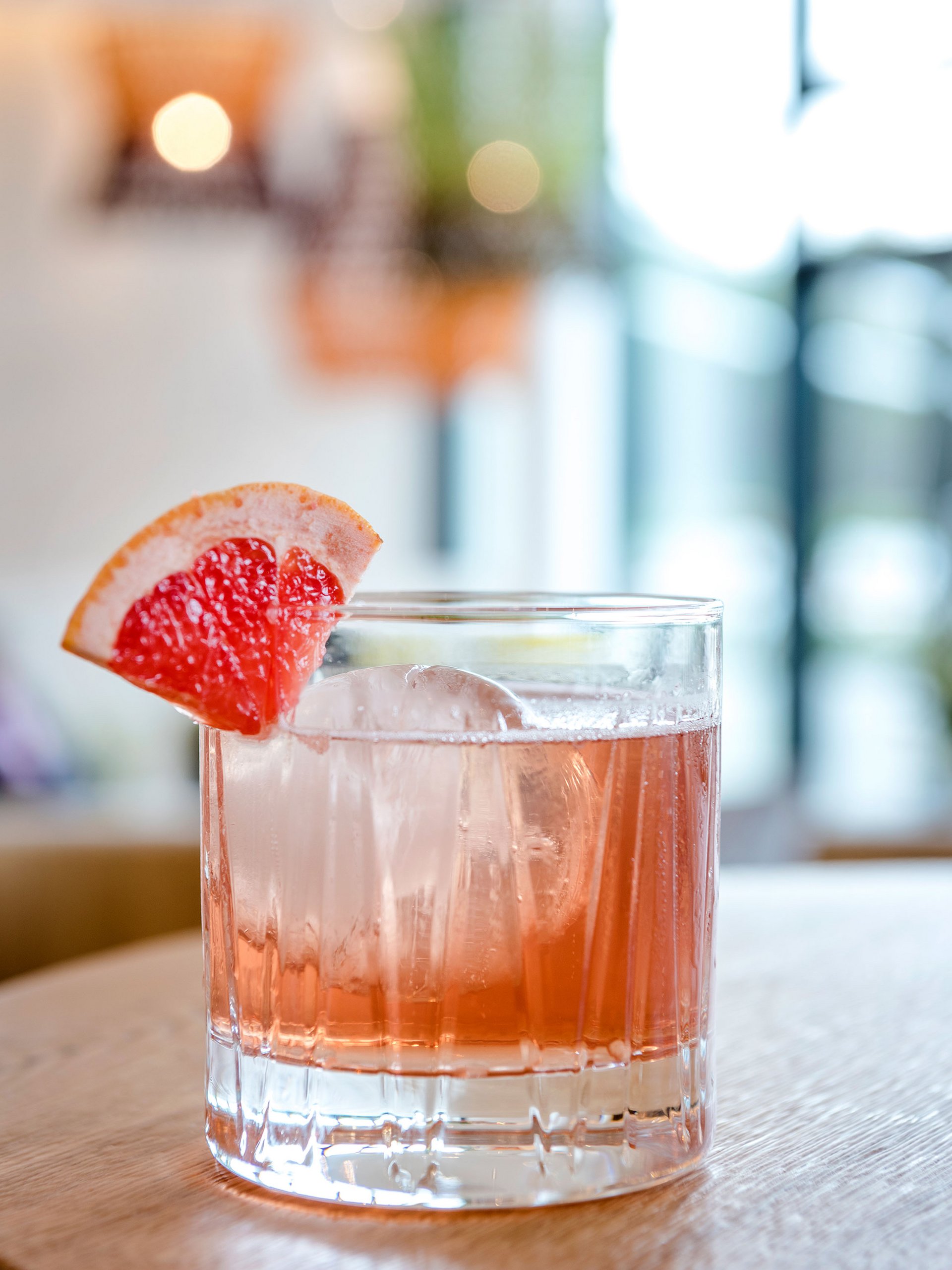 Cocktail avec glace et tranche de pamplemousse sur table en bois