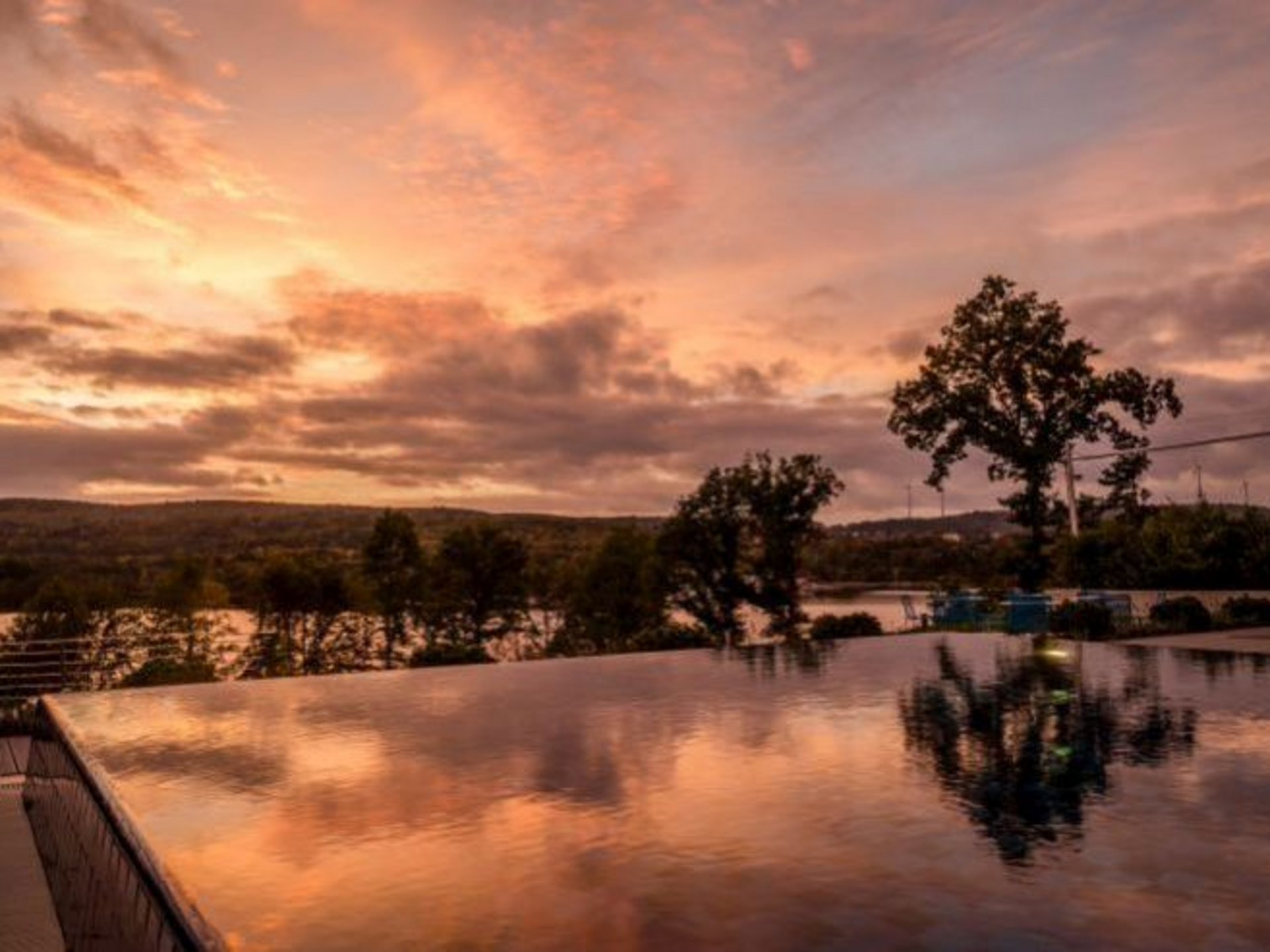 Herbstfarben rund um den Bostalsee entdecken Unendlich-Pool bei Sonnenuntergang mit Spiegelung und Bäumen im Hintergrund