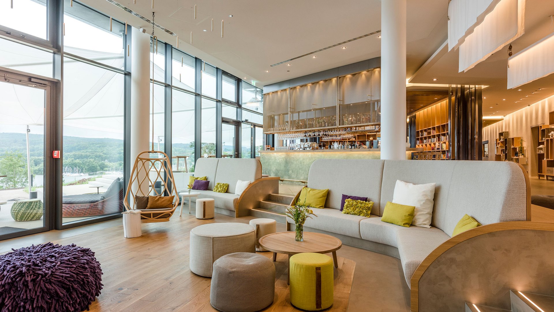 Moderne Lounge mit großen Fenstern, Sitzgelegenheiten und Barbereich