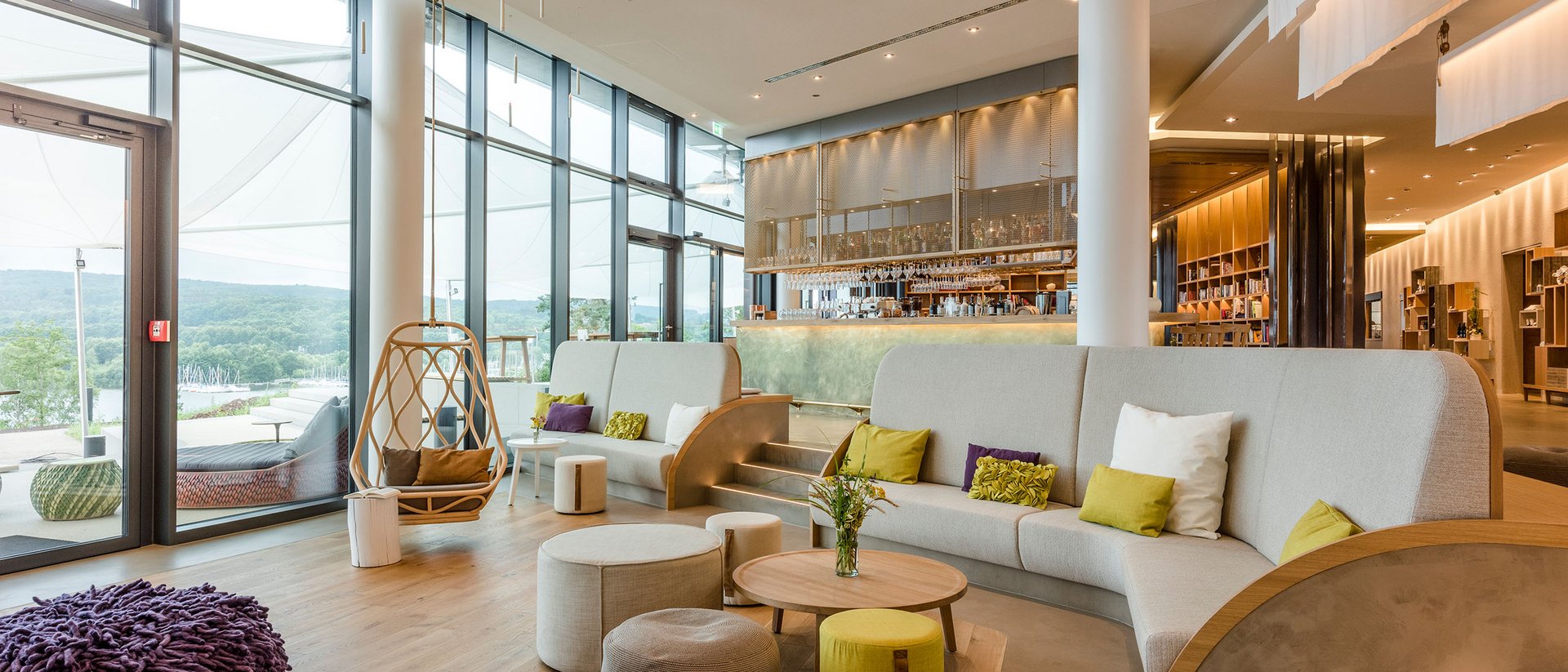 Moderne Lounge mit großen Fenstern, Sitzgelegenheiten und Barbereich