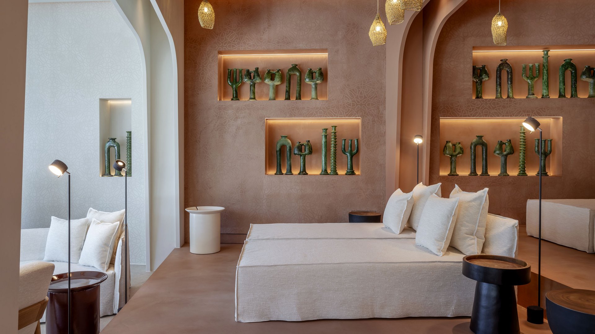 Salon moderne avec canapé beige, éclairage d'accent et sculptures vertes au mur.