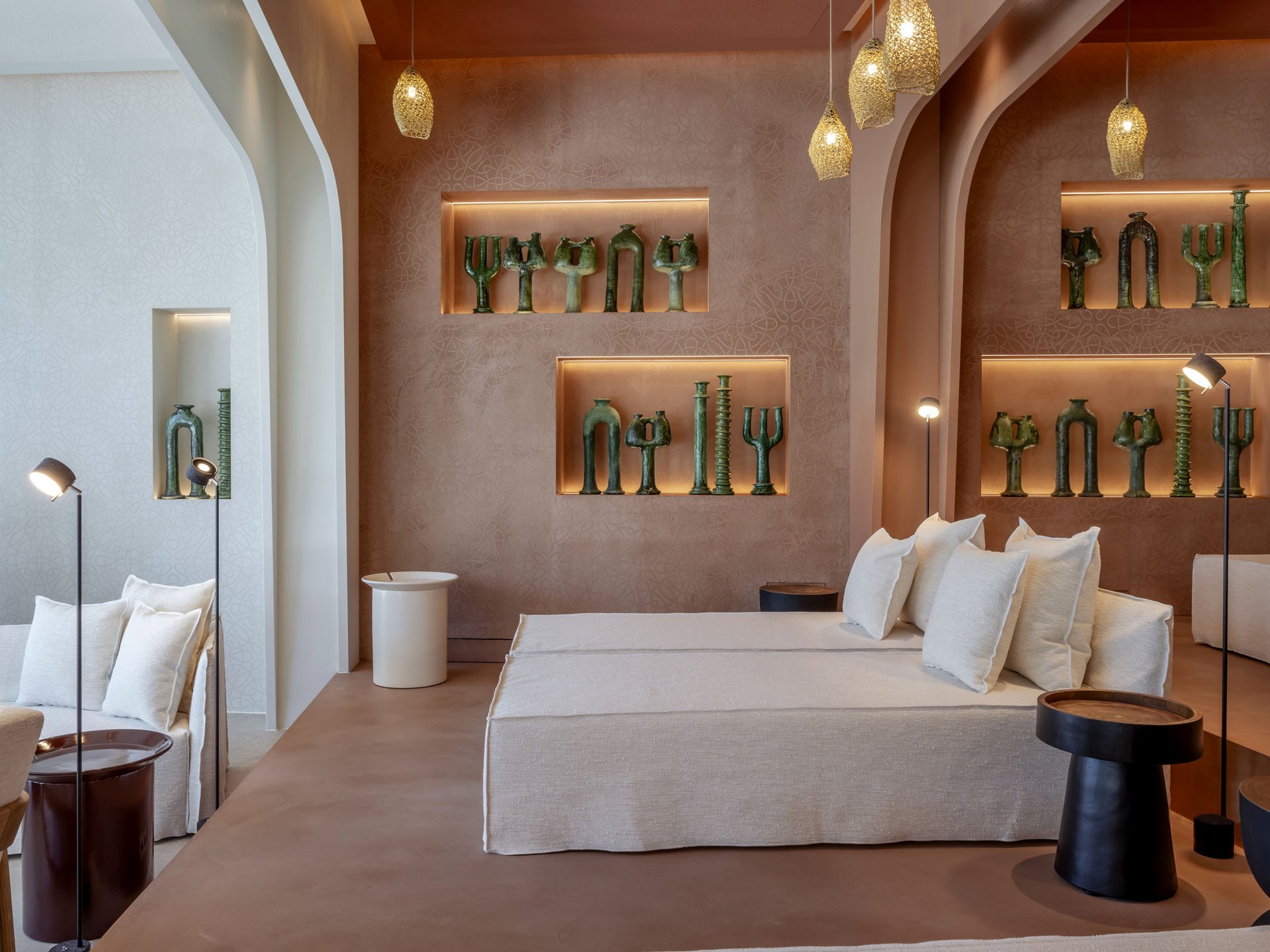 Modern living room with beige sofa, accent lighting, and green sculptures on the wall.