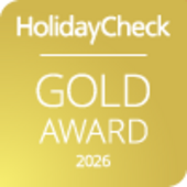 HolidayCheck Gold Award 2026 auf goldenem Hintergrund