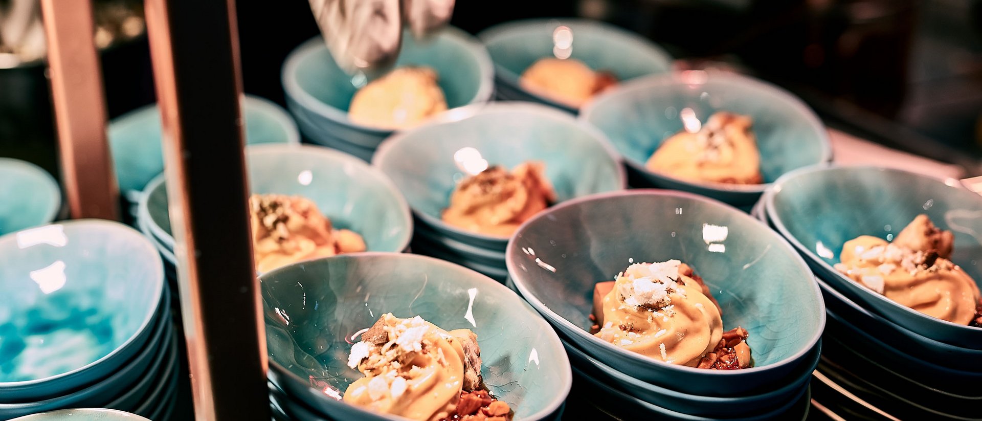 Ice cream with toppings in blue bowls, being hand-decorated in a restaurant