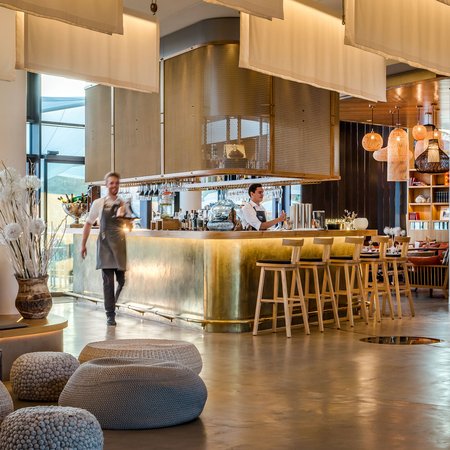Moderner Hotelbarbereich mit Bartresen aus Messing und Mitarbeitern