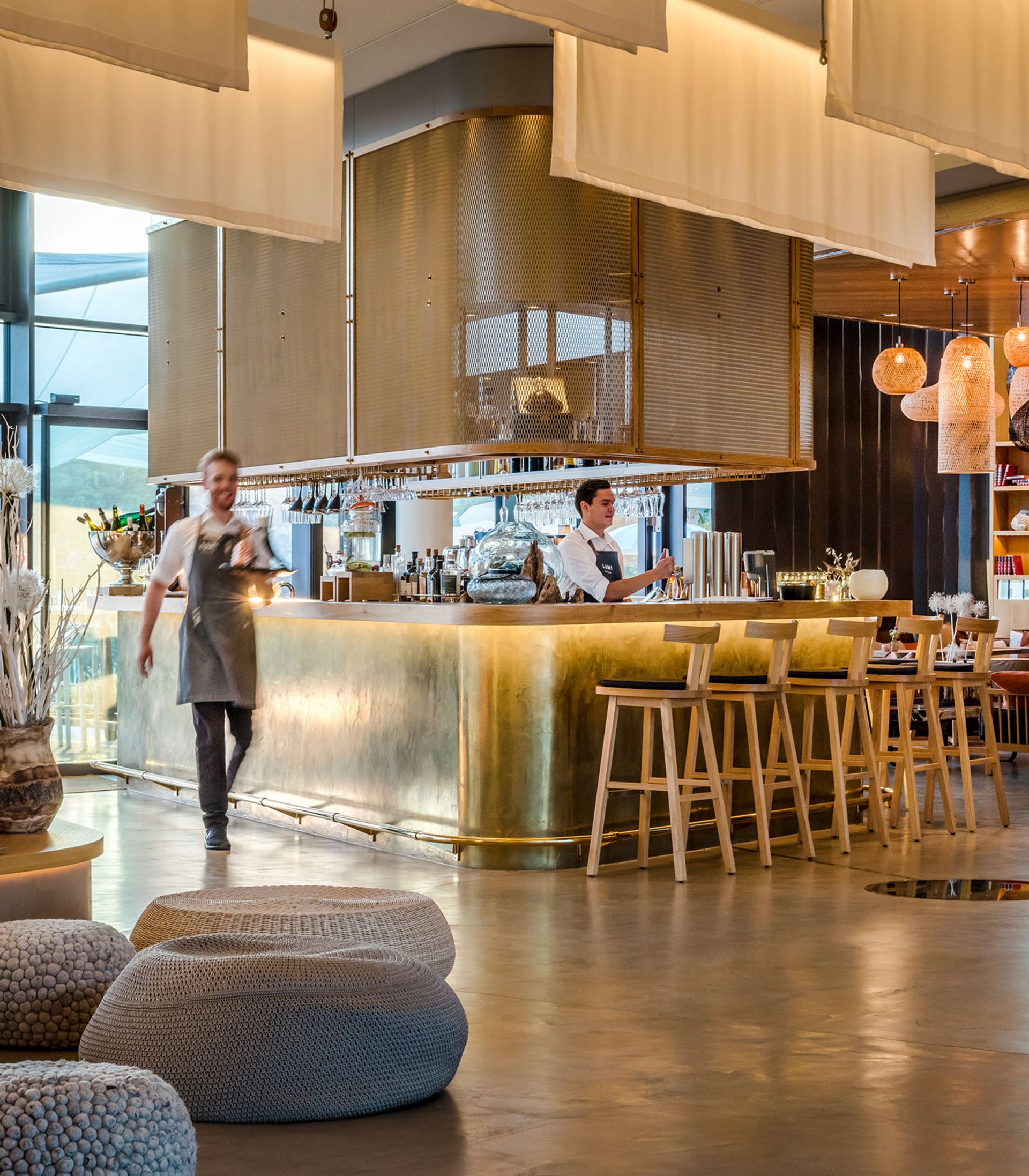 Die Seezeitlodge: Ihr Hotel am Bostalsee Moderner Hotelbarbereich mit Bartresen aus Messing und Mitarbeitern