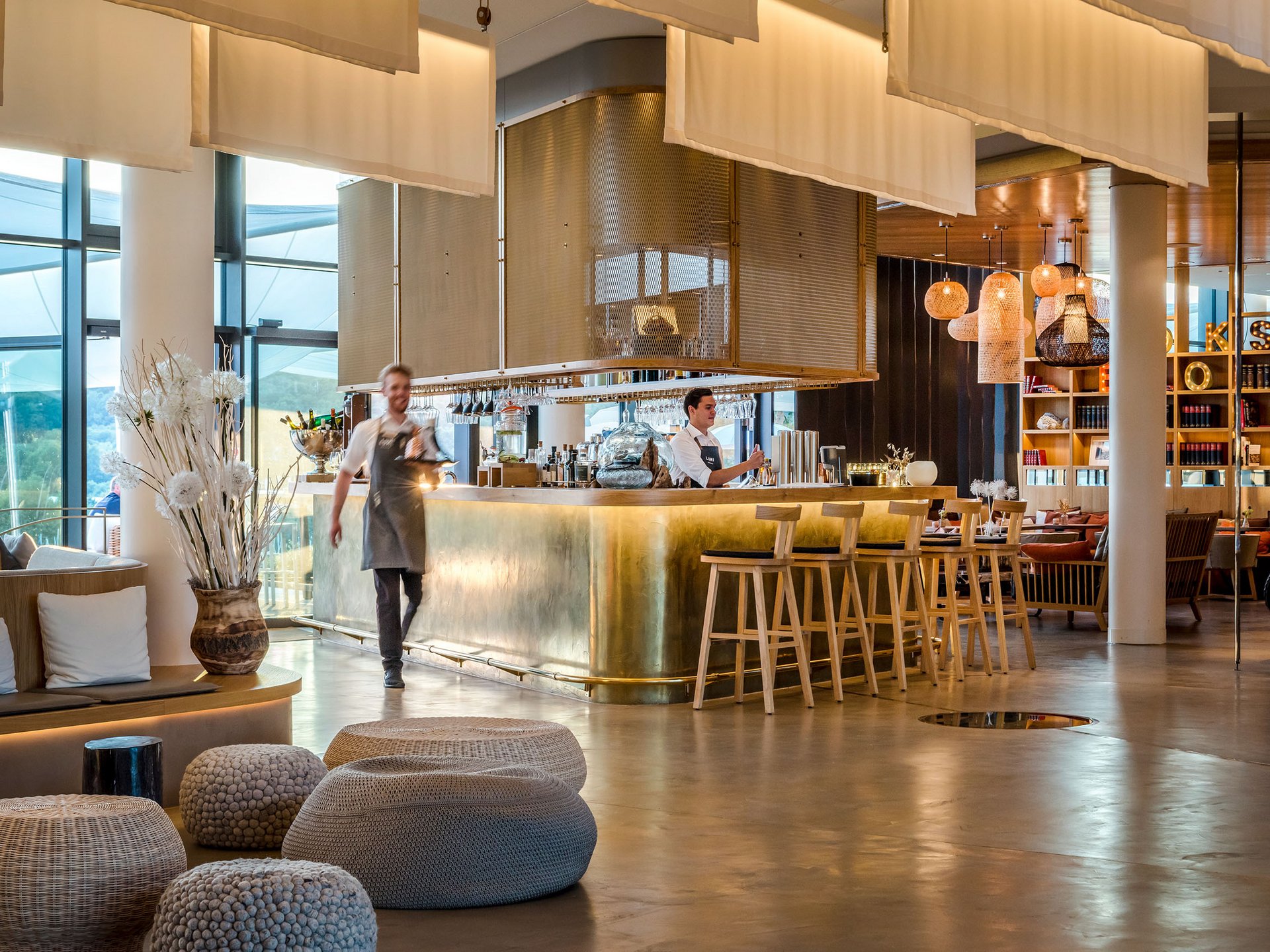Bar d'hôtel moderne avec comptoir en laiton et personnel