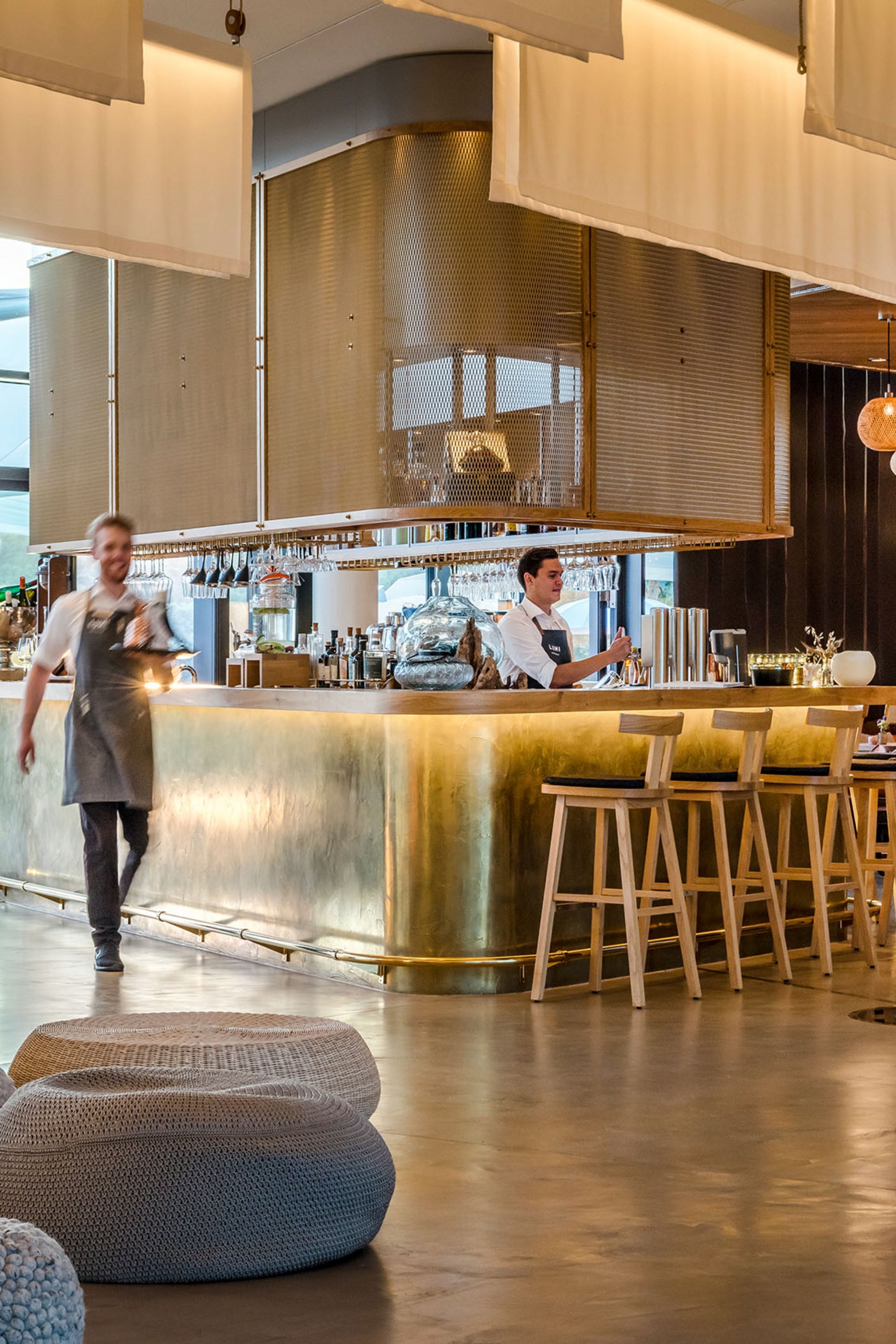 Moderner Hotelbarbereich mit Bartresen aus Messing und Mitarbeitern
