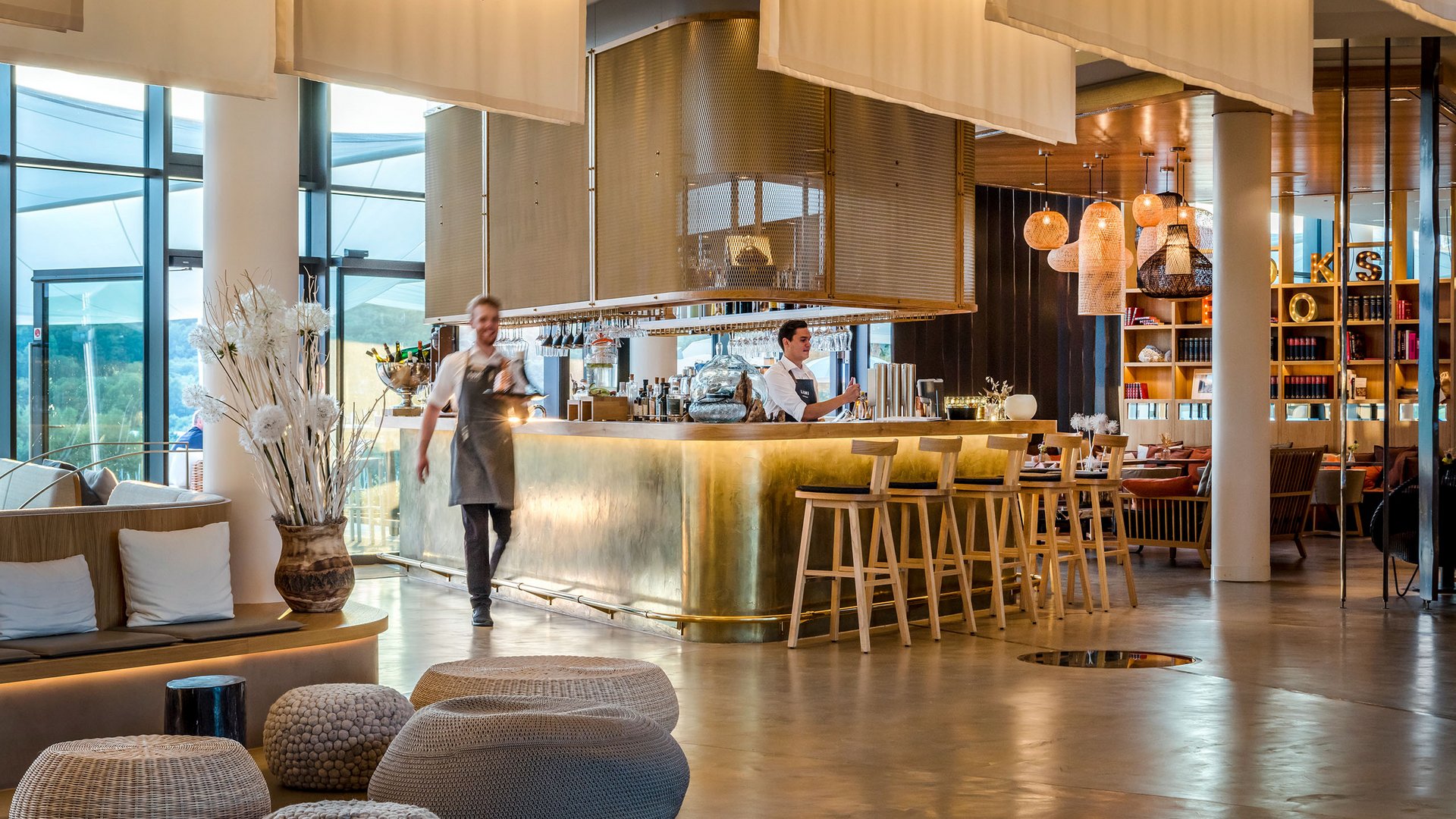 Modern hotel bar with brass counter and staff members