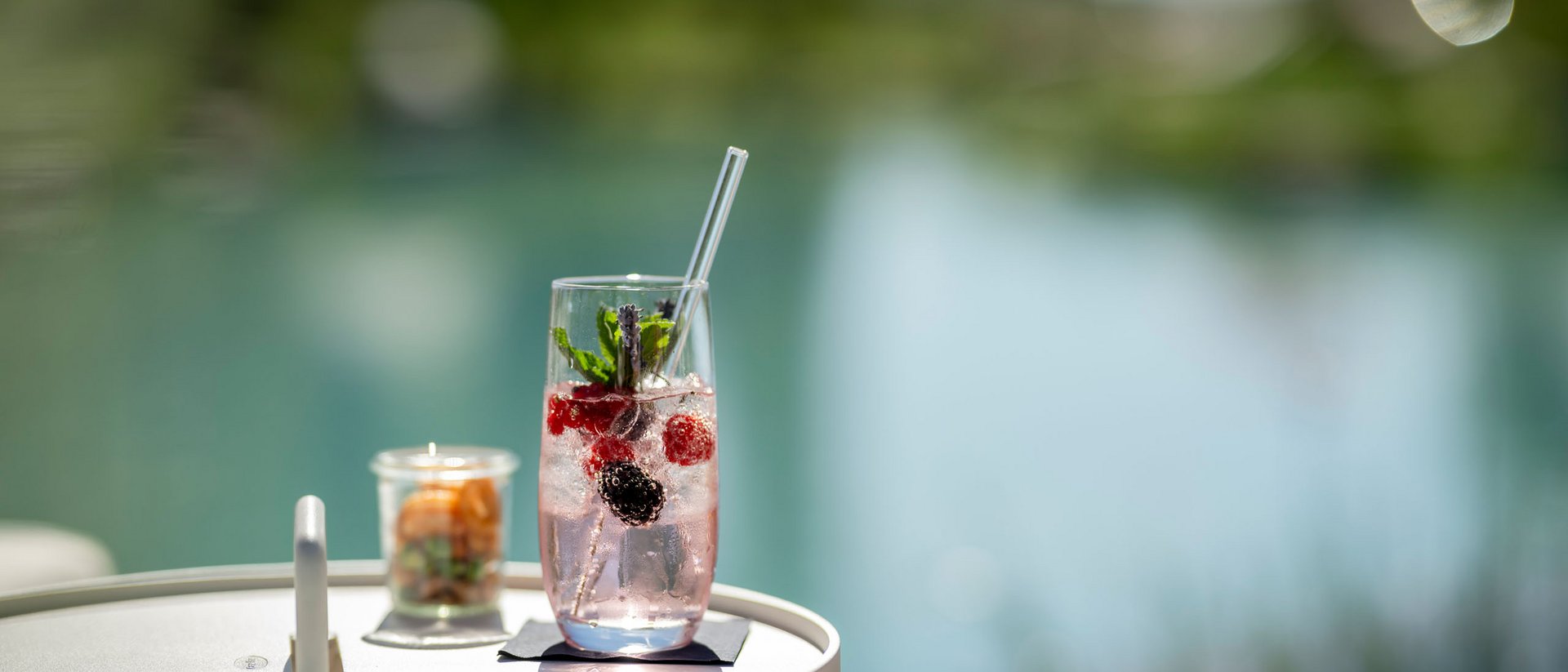 Boisson rafraîchissante aux baies et à la menthe sur une table blanche au bord de l'eau