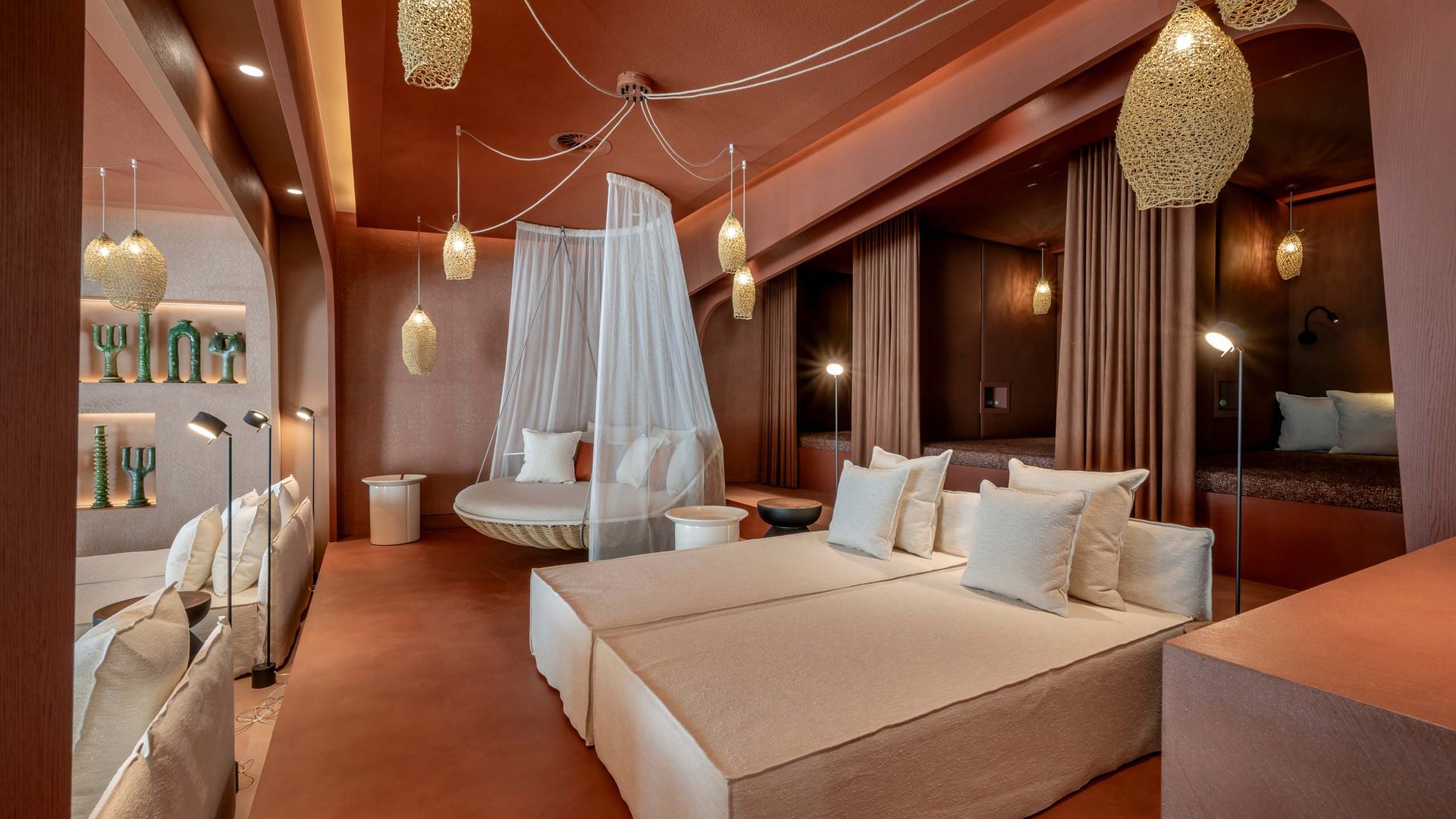 Moderne Lounge mit beigen Sofas, Hängesessel mit Netz und warmen Beleuchtungen