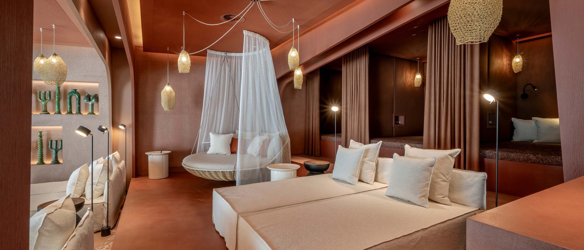 Moderne Lounge mit beigen Sofas, Hängesessel mit Netz und warmen Beleuchtungen