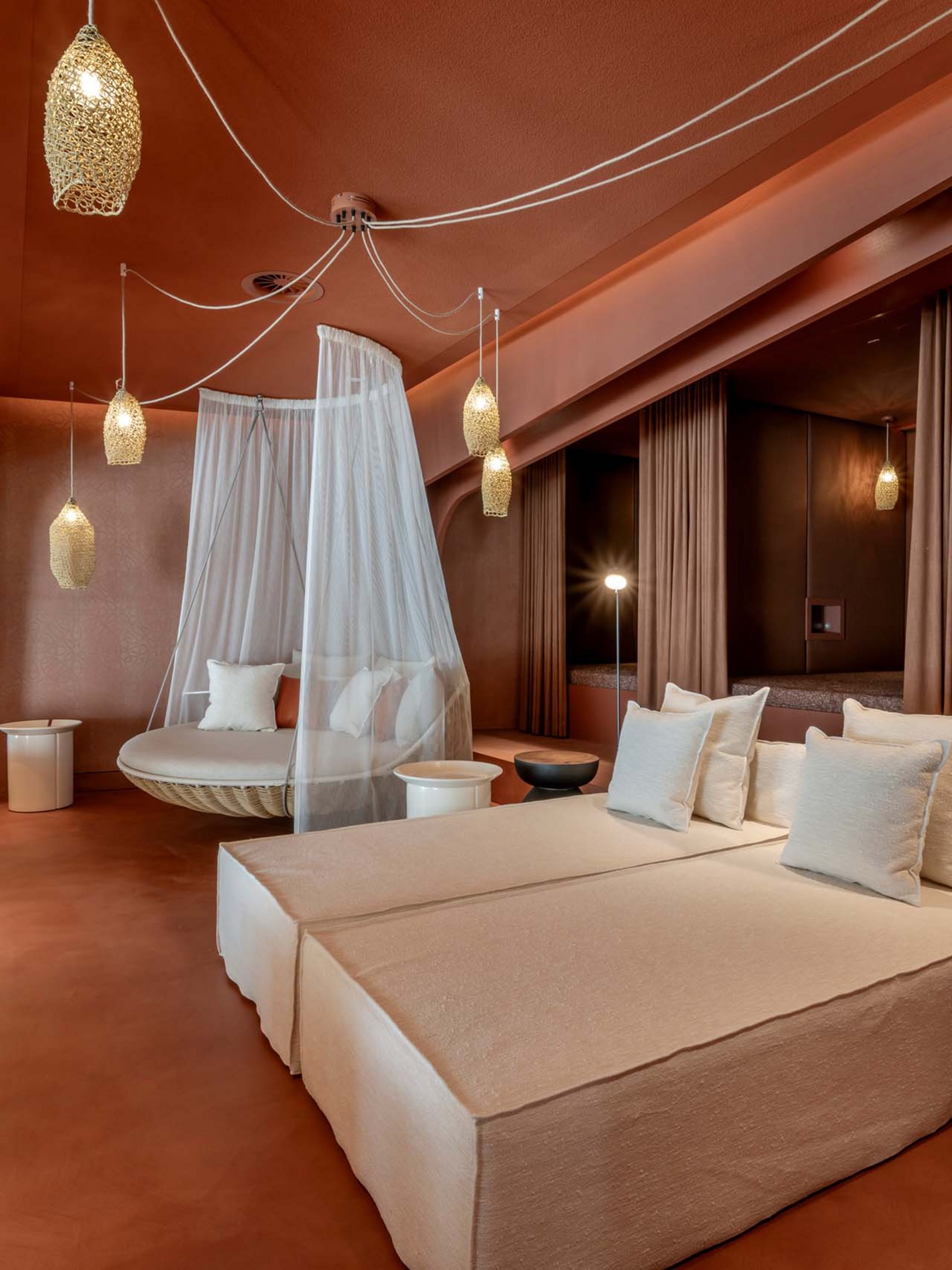 Modern lounge with beige sofas, hanging net chair, and warm lighting