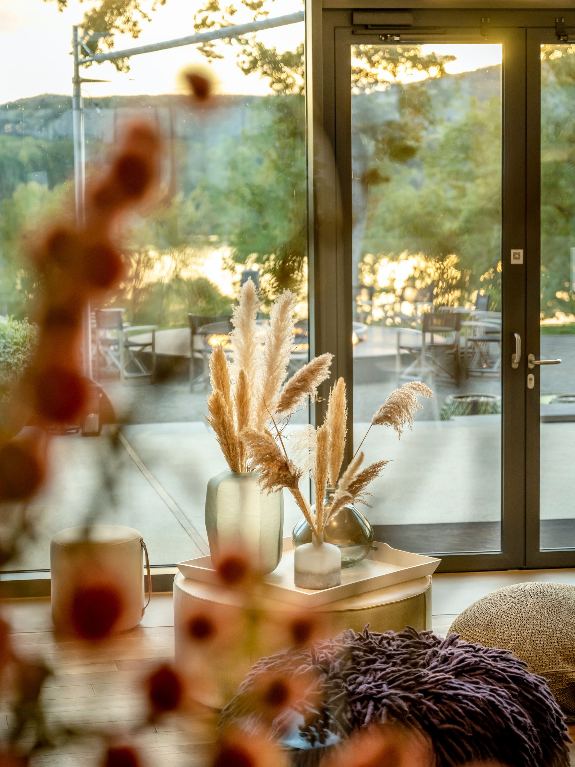 Intérieur confortable avec vue sur terrasse et lac au coucher du soleil