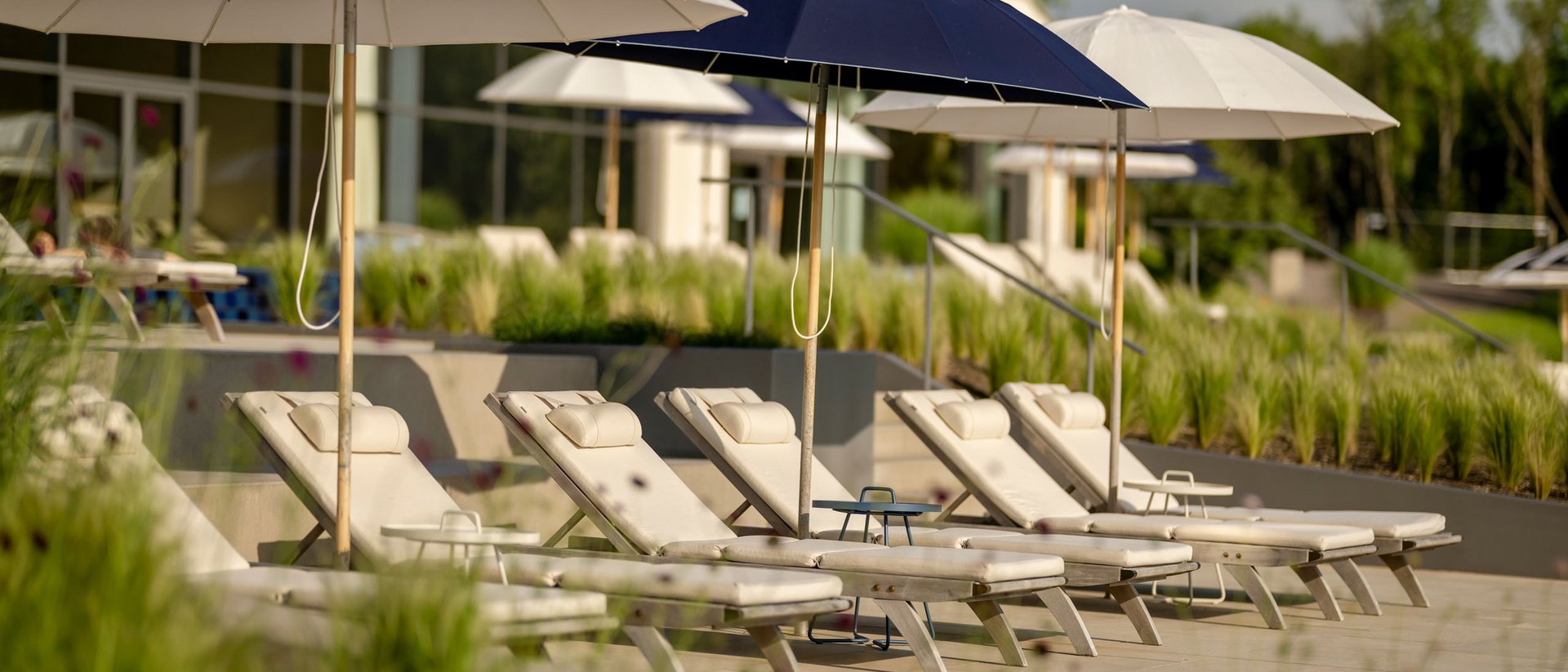 Chaises longues vides avec parasols dans une zone de piscine ensoleillée