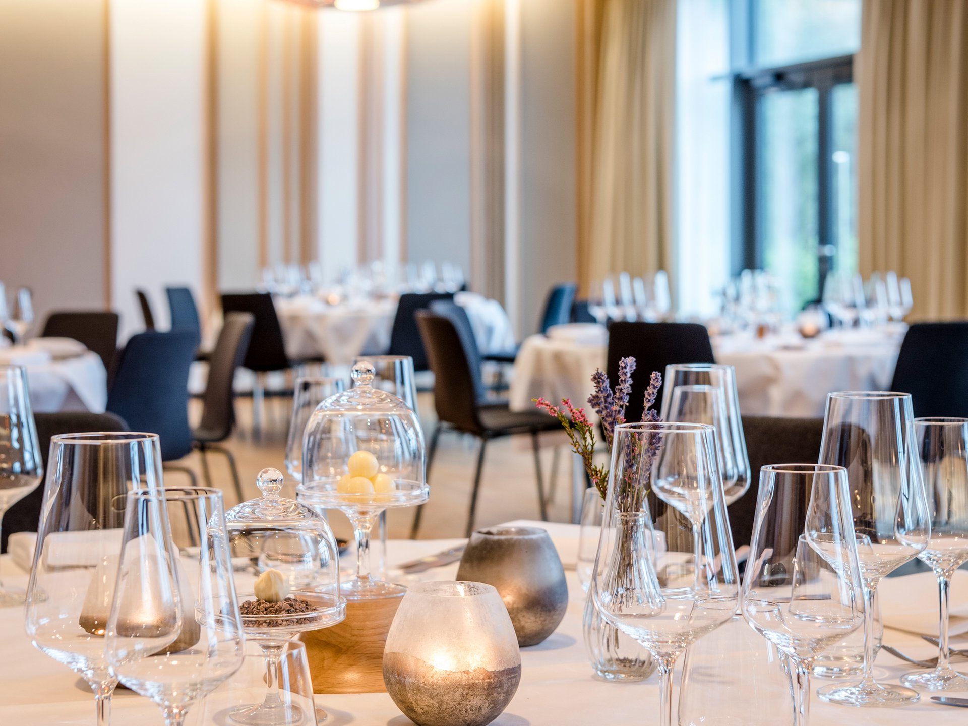 Elegant gedeckter Tisch in modernem Restaurant mit Kerzen und Glaswaren